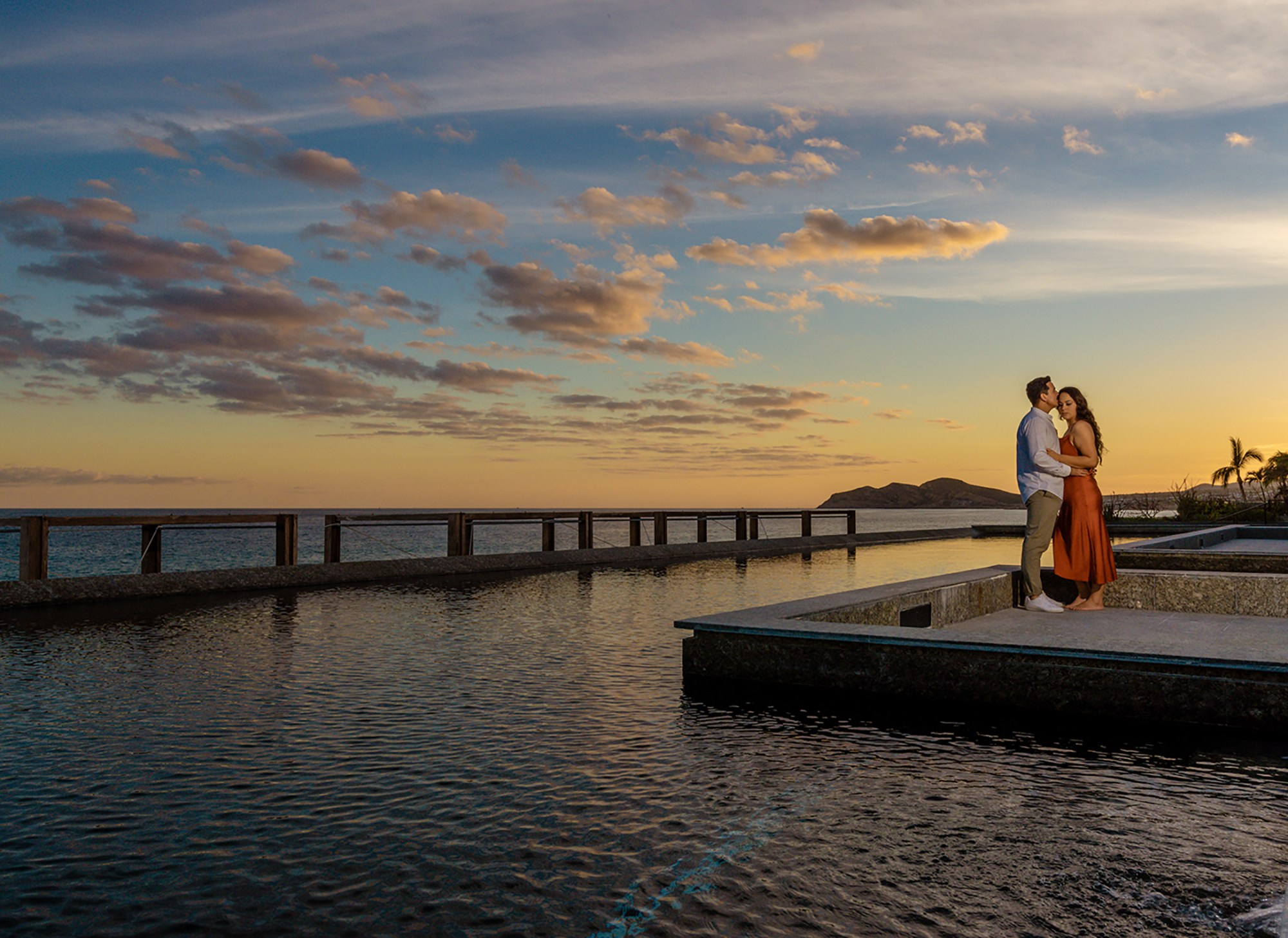 Romantic couple photoshoot at Solaz Resort Los Cabos – sunset portrait by reflecting pool, luxury destination photography
