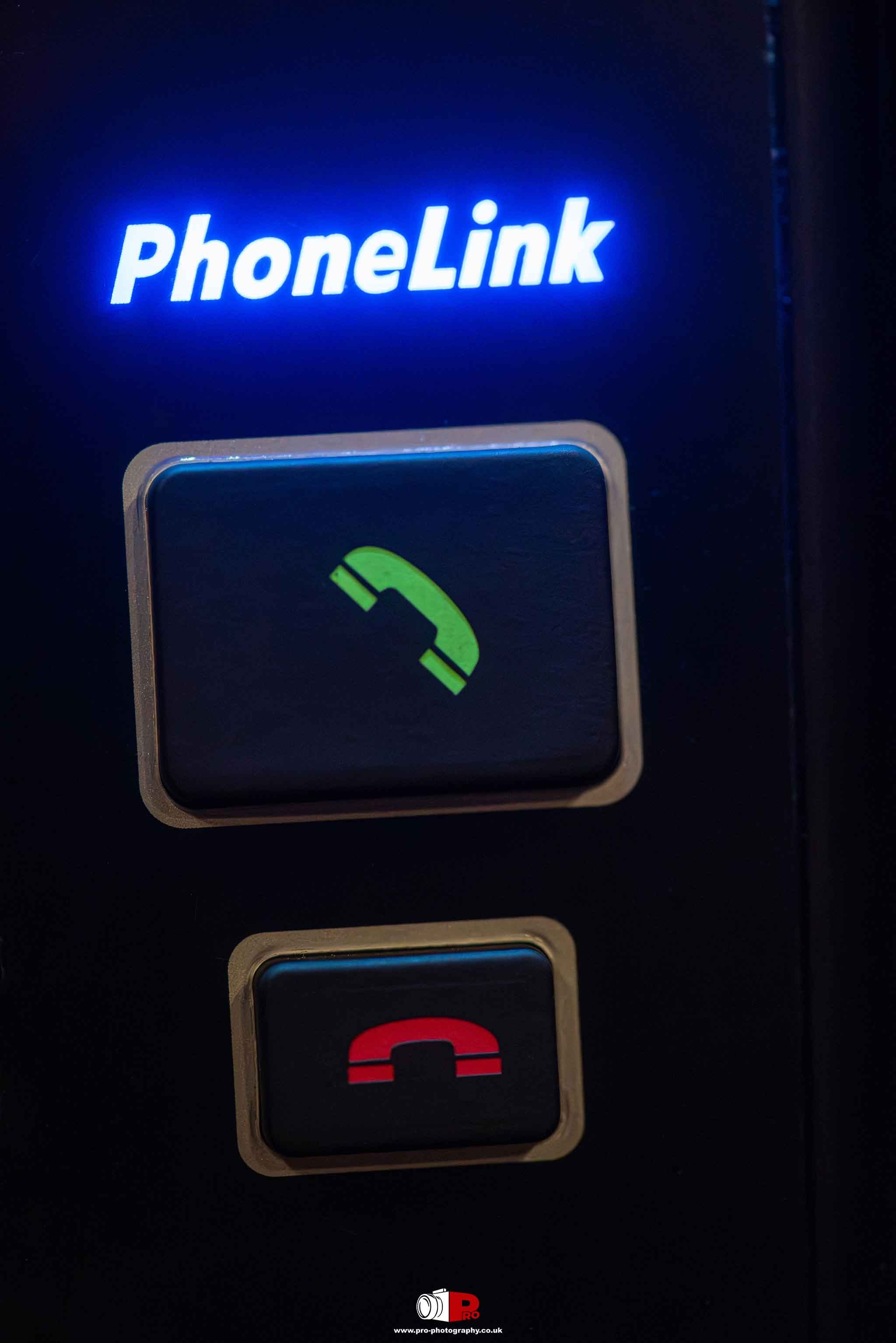 Close-up of a PhoneLink system with illuminated green and red call buttons for easy communication.