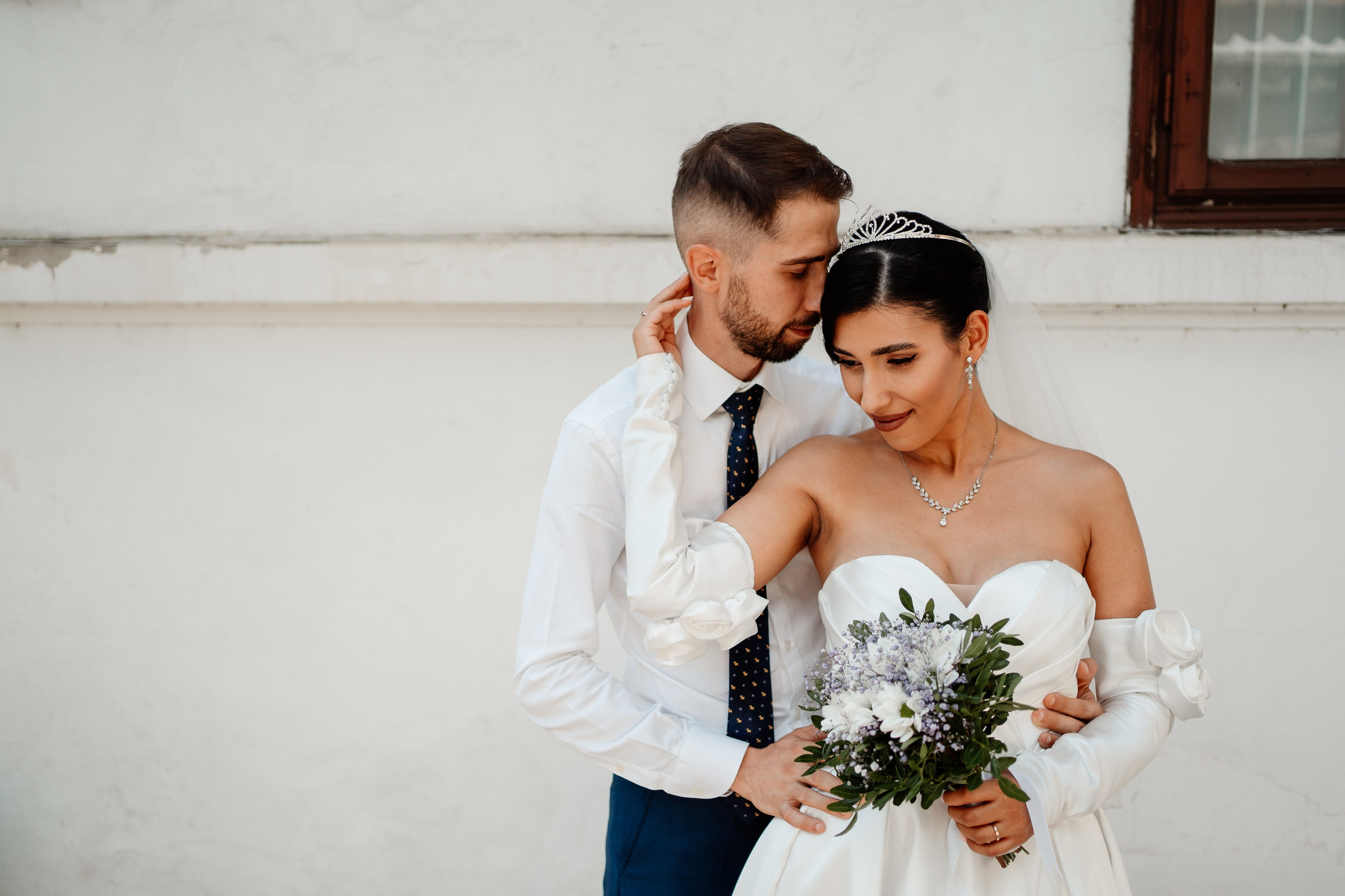 Moment emoționant între miri în ziua nunții, surprins într-un cadru natural și romantic, in Bucuresti. Fotografie de nuntă profesională, editată artistic pentru a evidenția emoția și eleganța evenimentului.