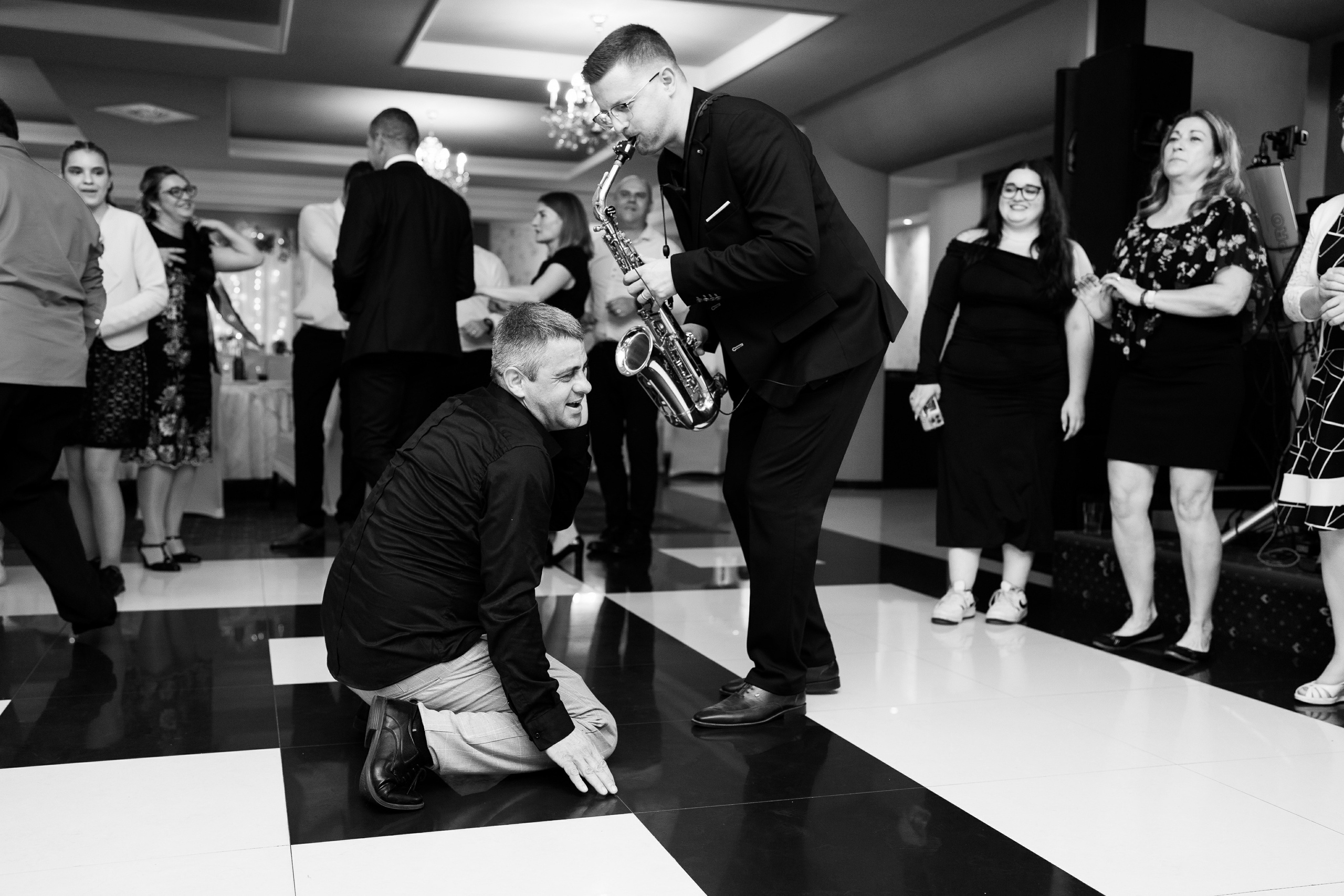 Saxofonistul ii canta unui invitat la ureche 