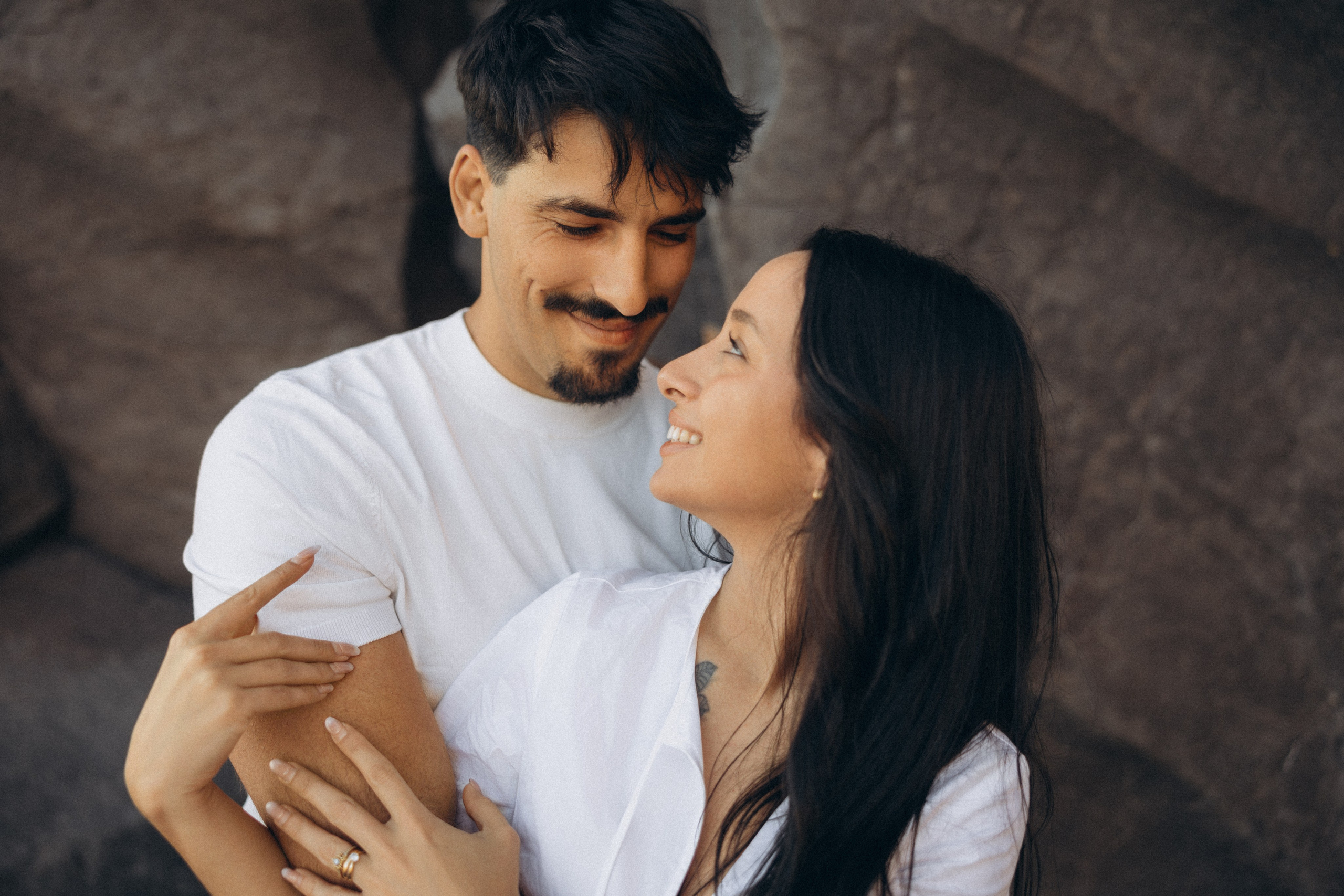 Couple sharing a romantic moment during sunset on Madeira Island, with the ocean and cliffs in the background