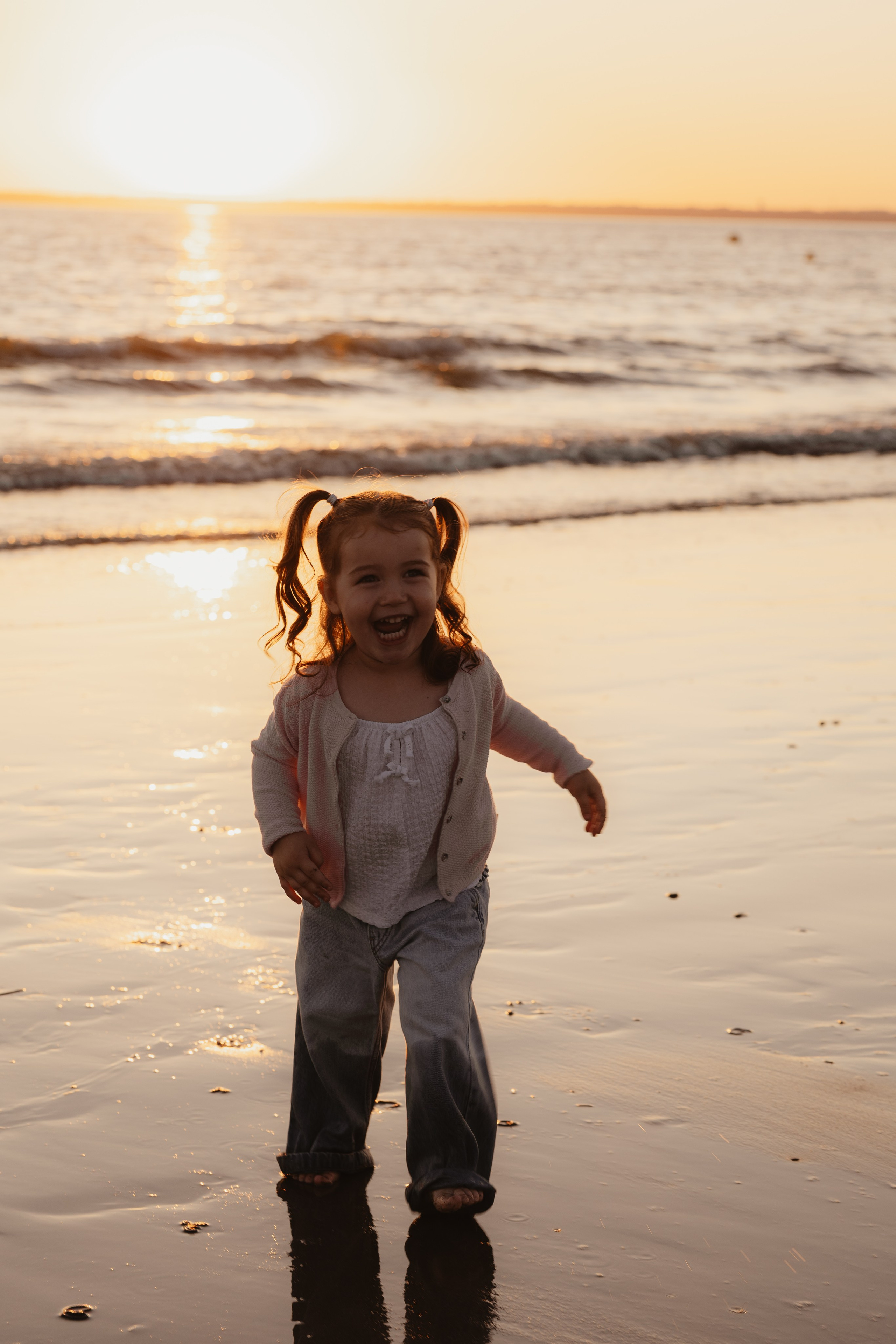 Enfant courant sur le sable au coucher du soleil, photo lifestyle pleine de mouvement