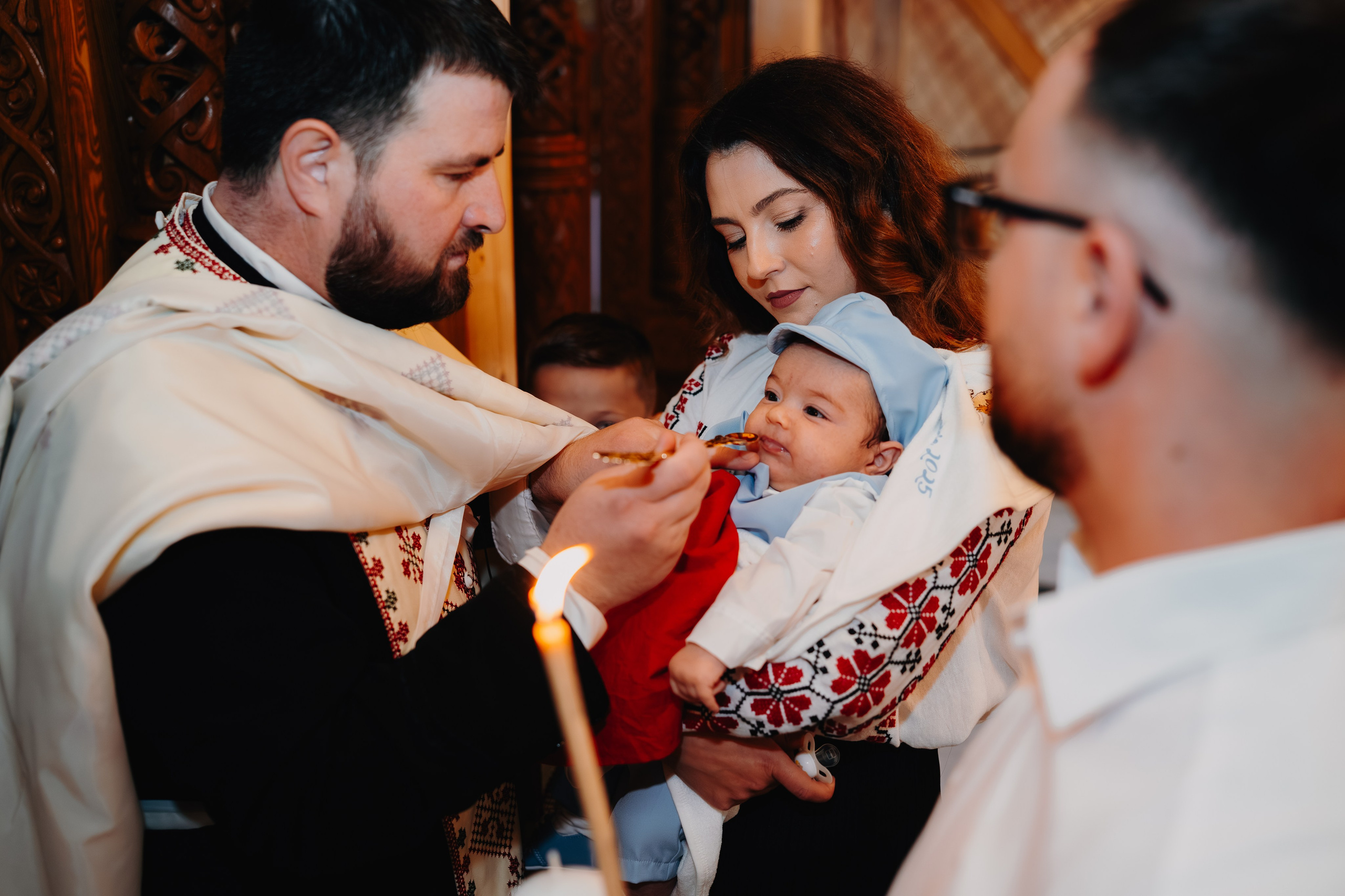 Ultimul act solemn al botezului lui Arthur Mihail în Catedrala Bârlad: în fața altarului, preotul dă prima Împărtășanie pruncului, pe care nașa îl ține în brațe, în timp ce nașul și familia asistă. Sfârșitul ritualului și începutul vieții în credință.