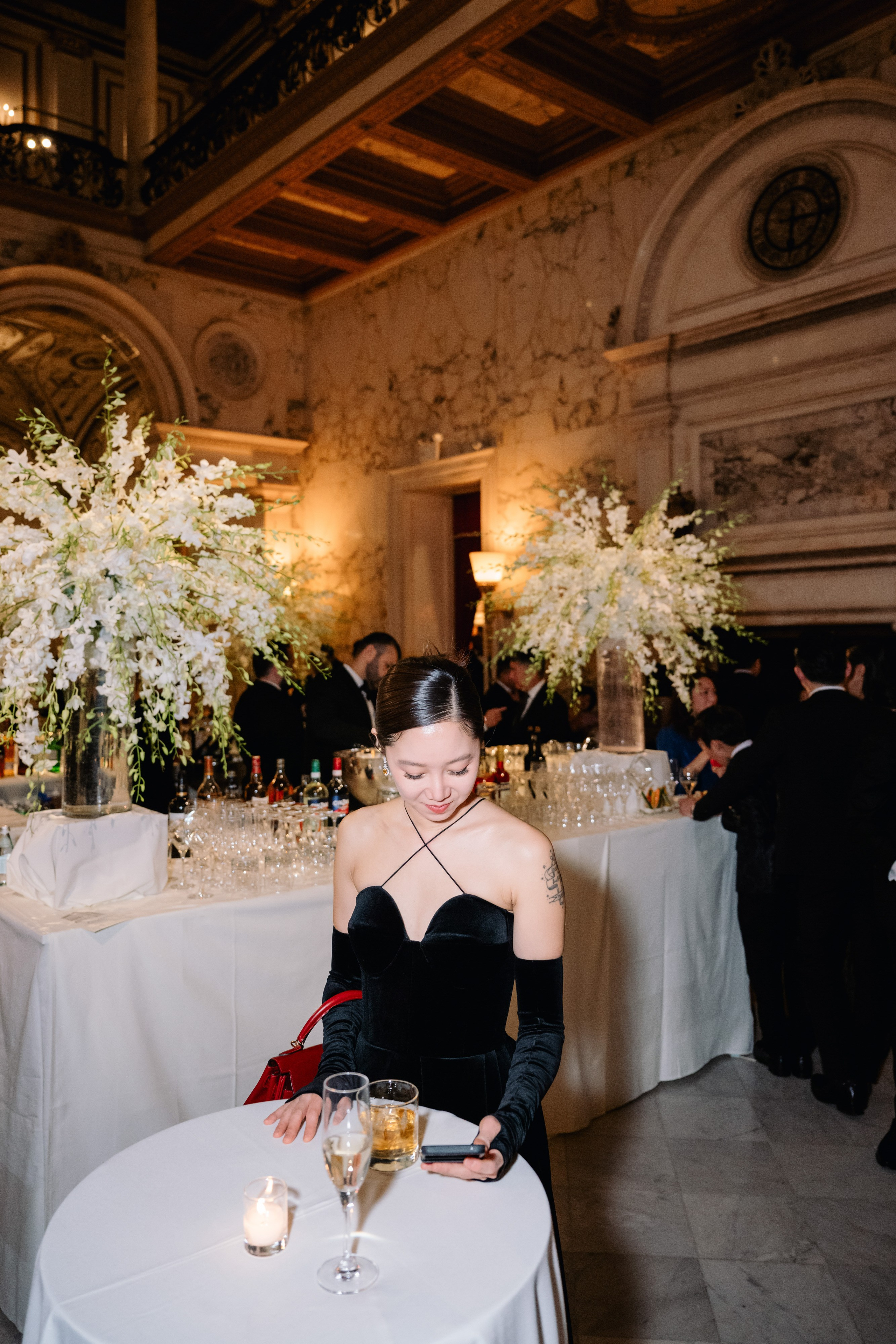 a woman sitting at a table with a glass of wine