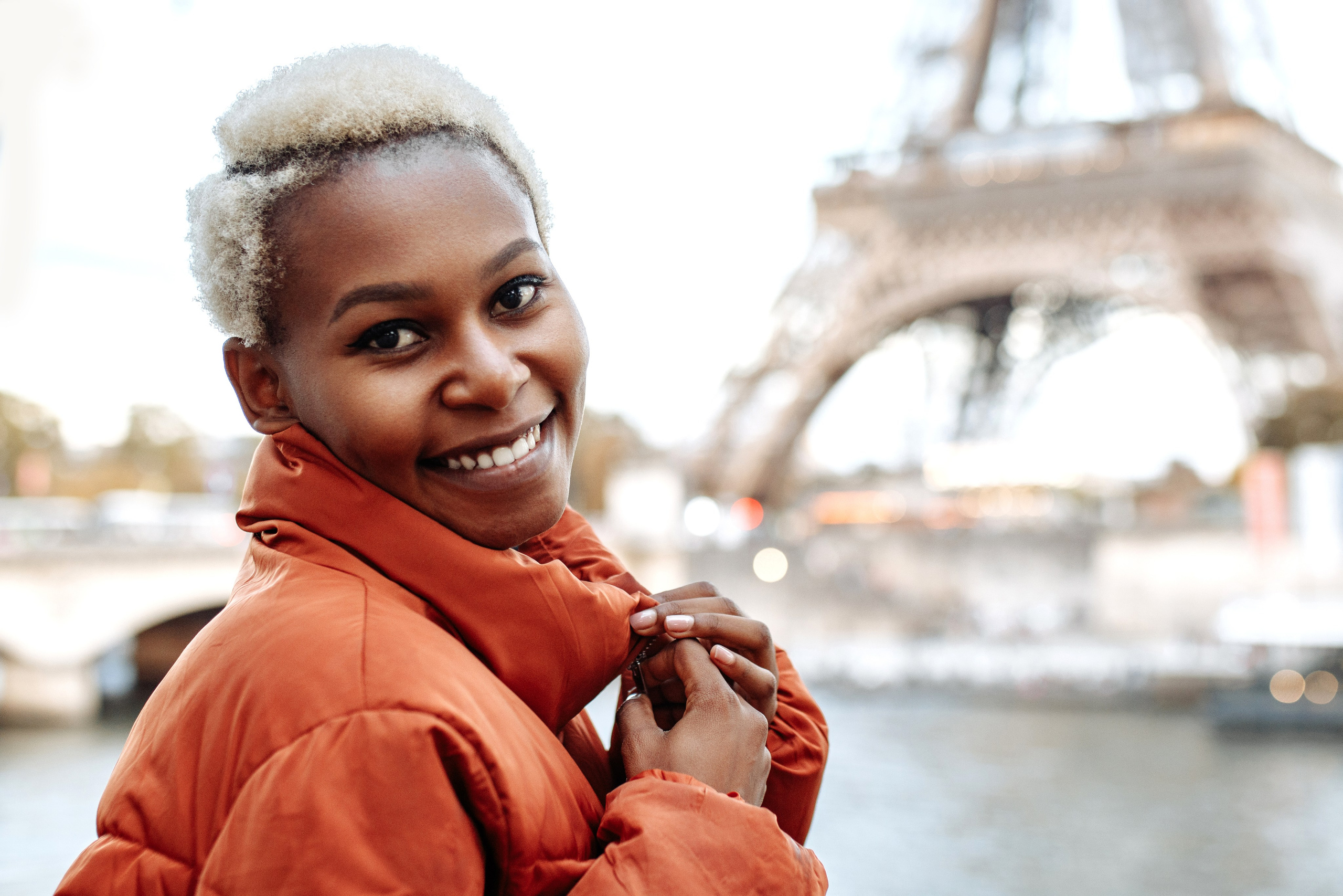 Девушка в куртке у Эйфелевой башни