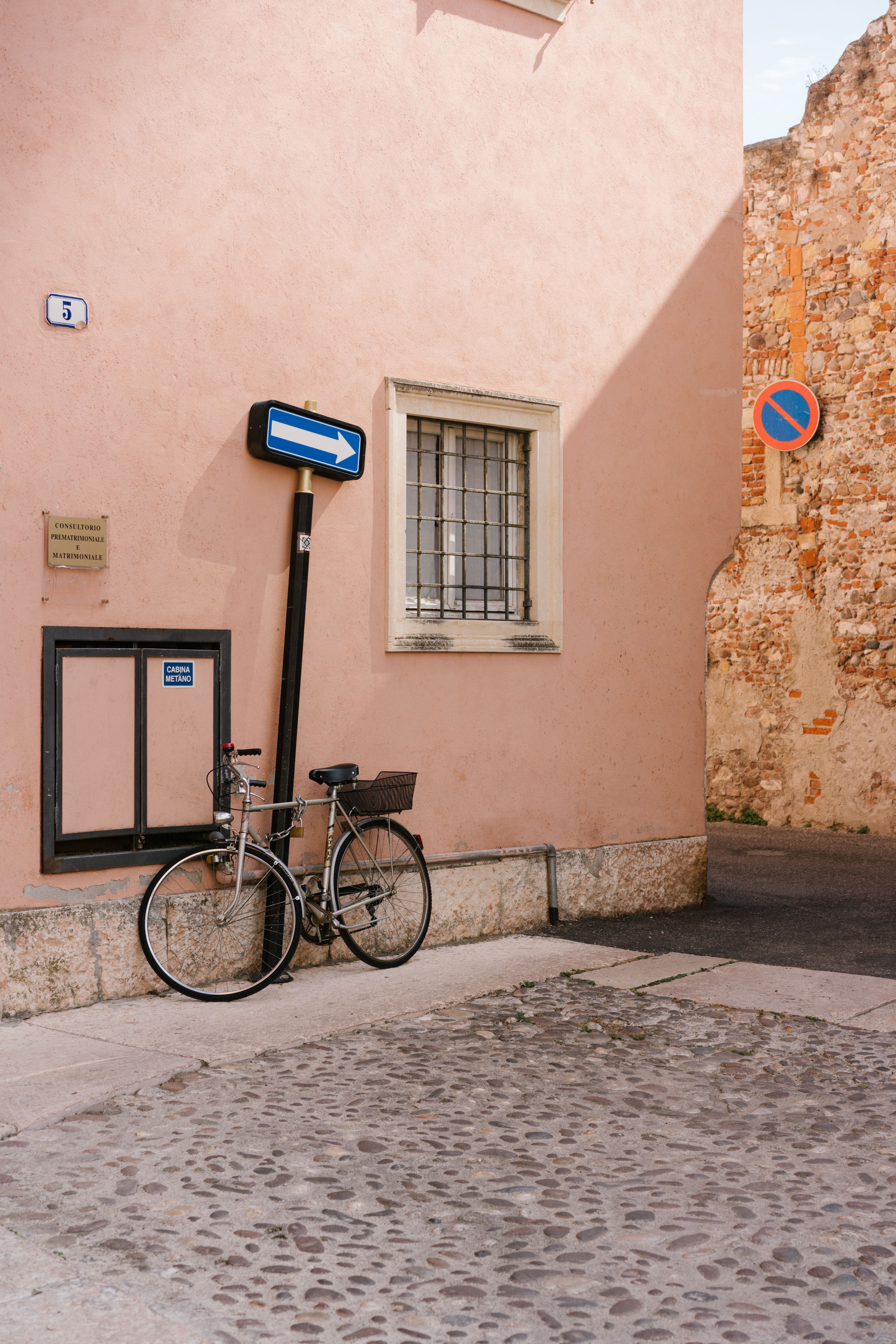 Das Fahrrad steht in der Nähe der rosa Wand auf der Straße