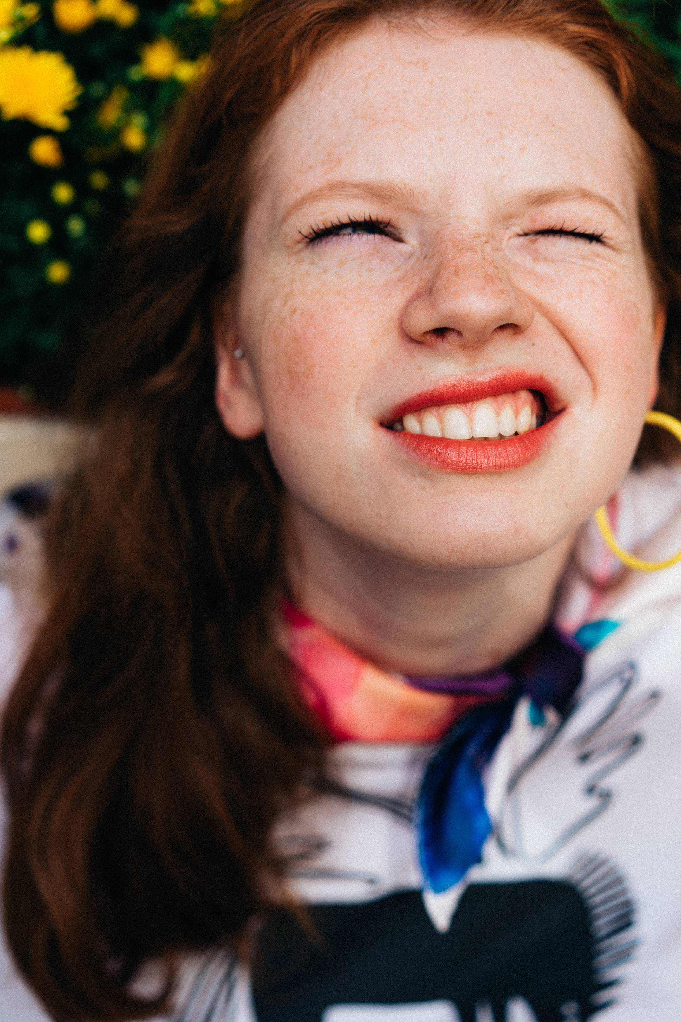 Teenagerin Redgirl lächelt in die Kamera und blickt in den Himmel