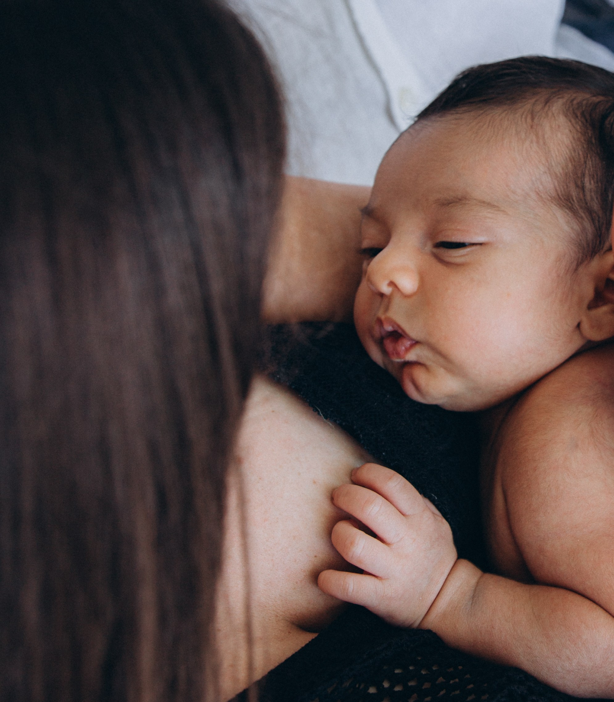 Primer plano de madre y recién nacido en Calpe, España — sesión familiar íntima que resalta el vínculo especial entre madre y bebé.