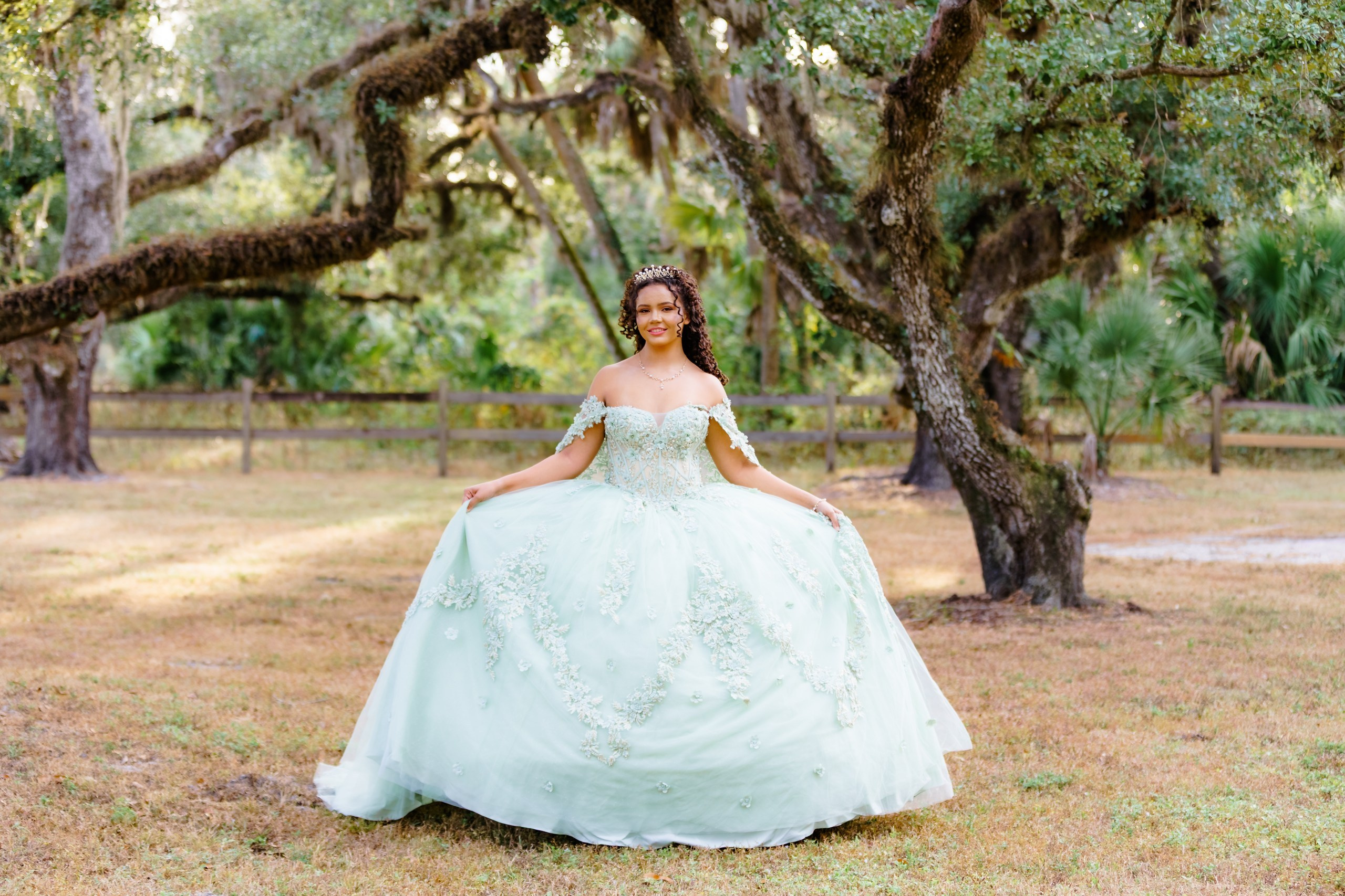 Portrait of young girl in beautiful dress with oak trees background 
