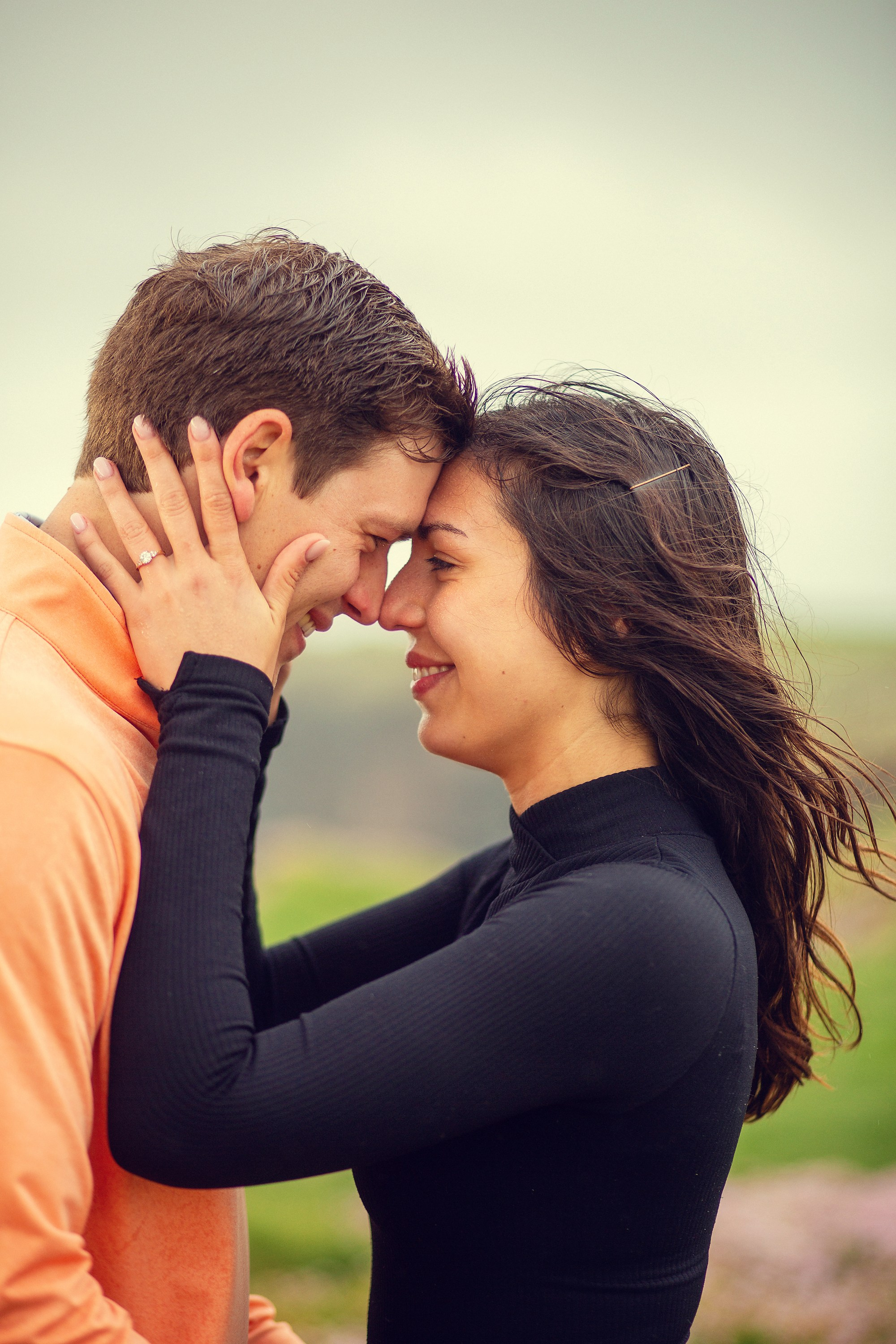 An intimate, close-up portrait of a newly engaged couple with their foreheads touching, captured near Doolin, Ireland.