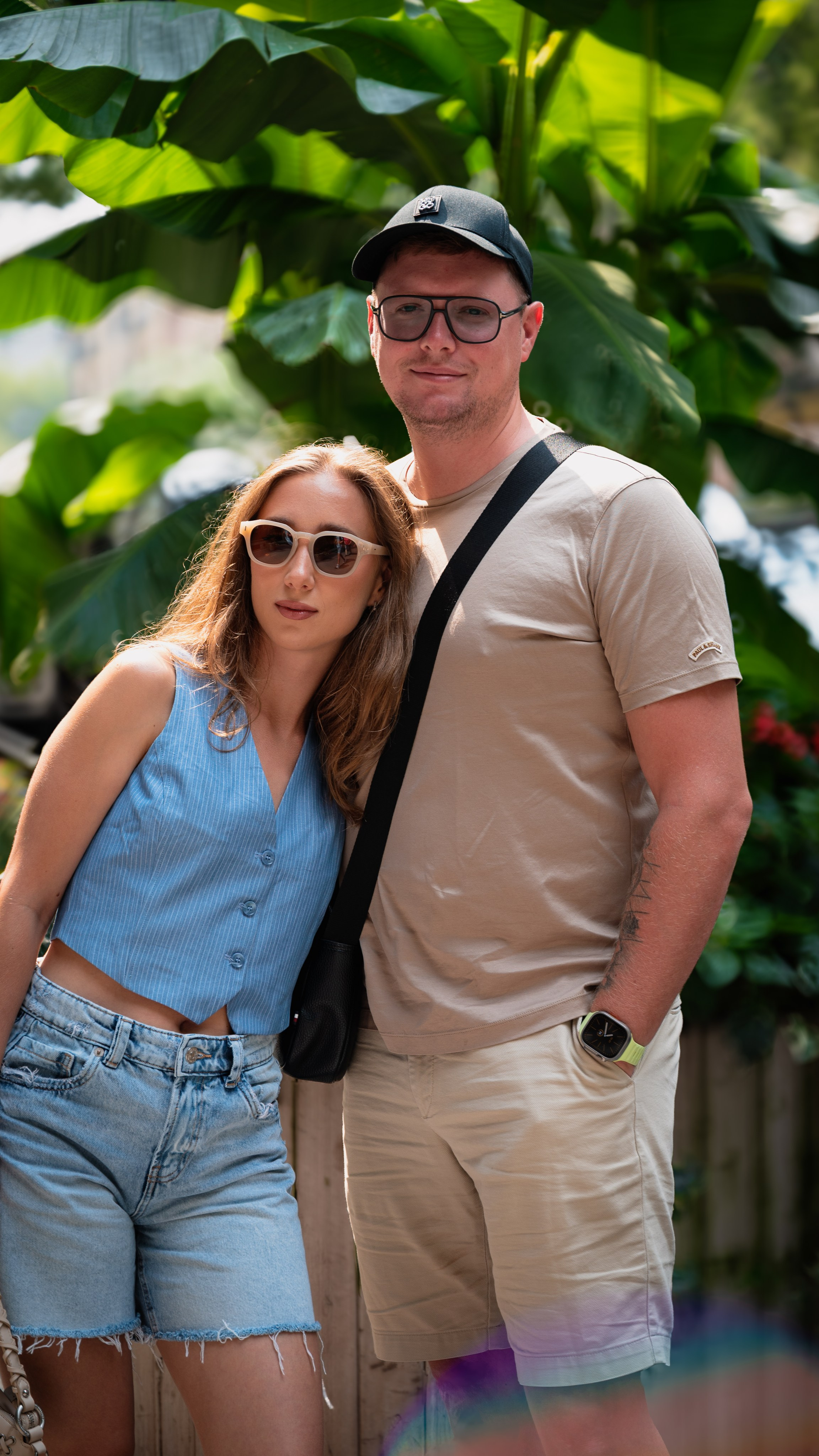 Couple standing together in a green park, casual summer outfits, candid lifestyle couple photography in NYC.