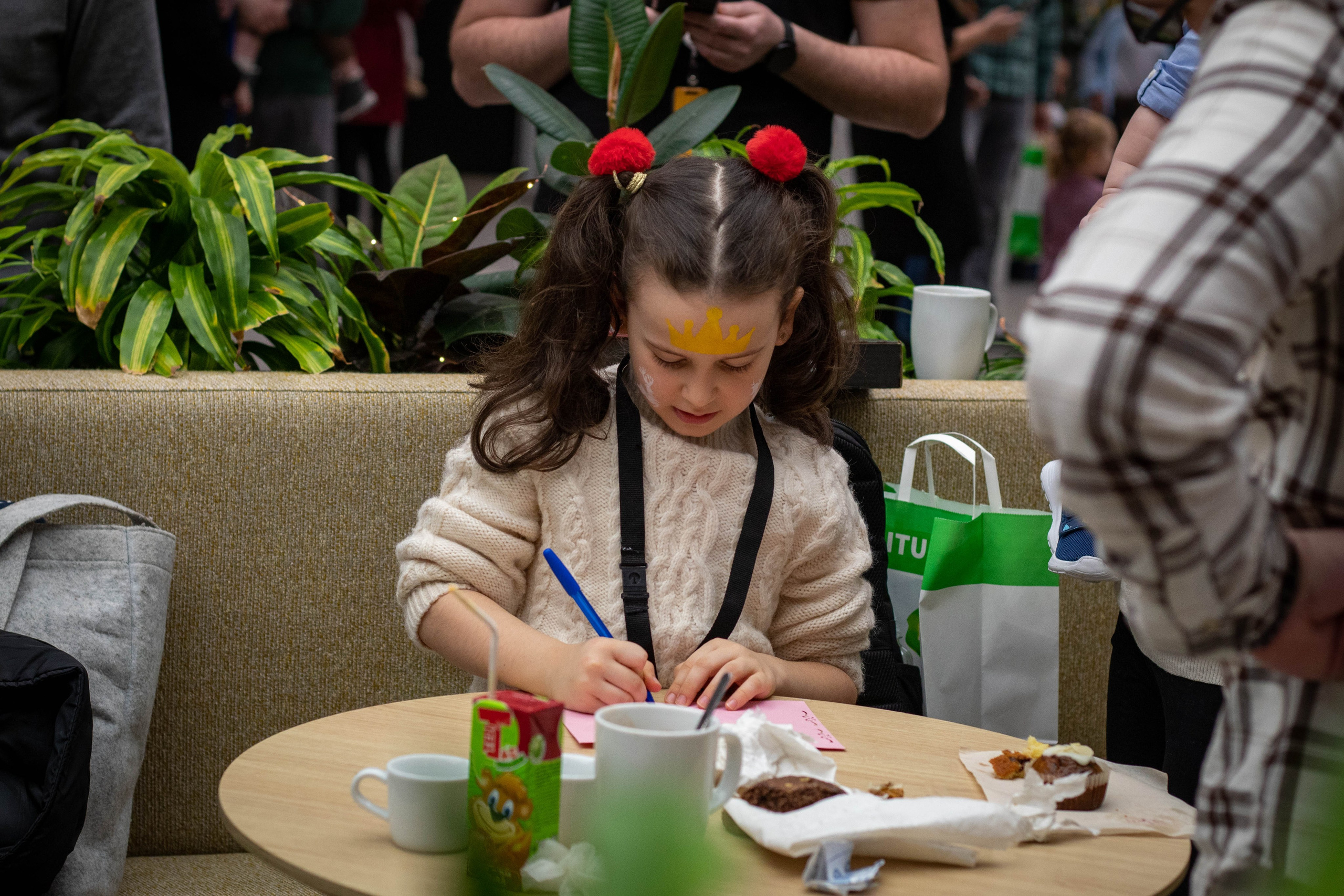 Children sitting around a table painting with colorful brushes and paper.