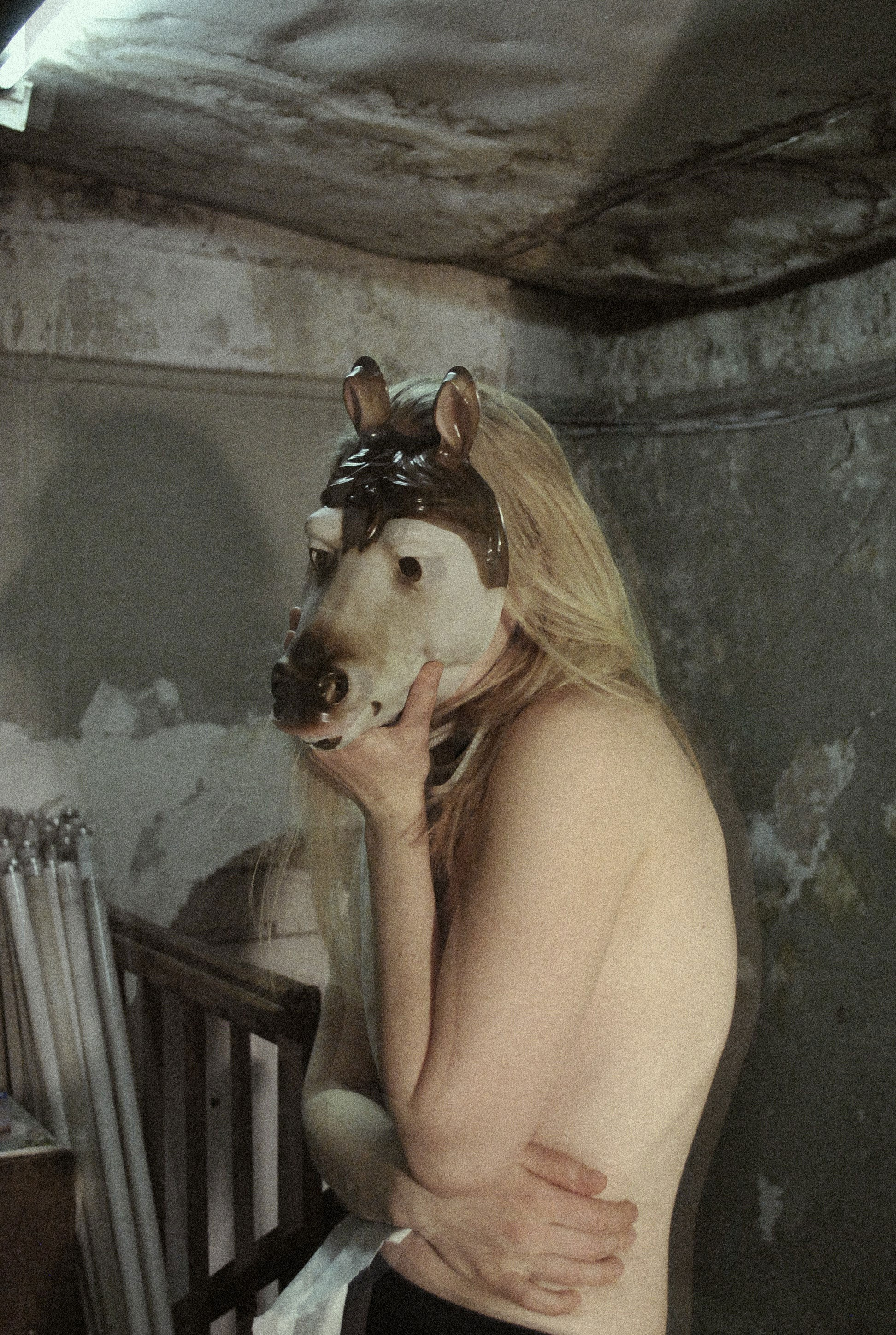 Artistic photograph of a nude female figure with an obscured face, posed in a contemplative stance against a neutral backdrop, from Leni Smoragdova's 'Figures Collection: Past Version' (2020).