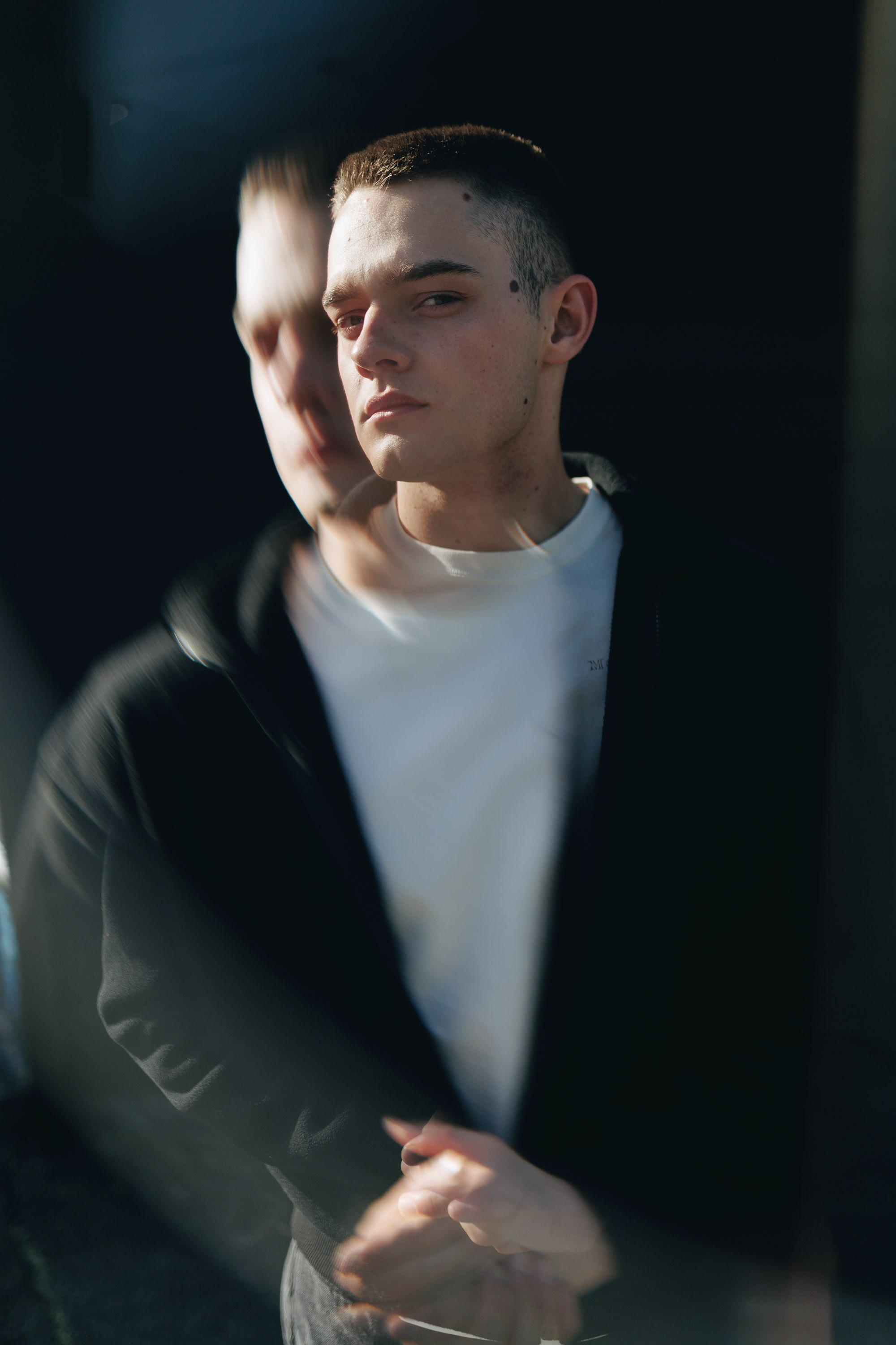 Smiling man in black jacket, arms crossed