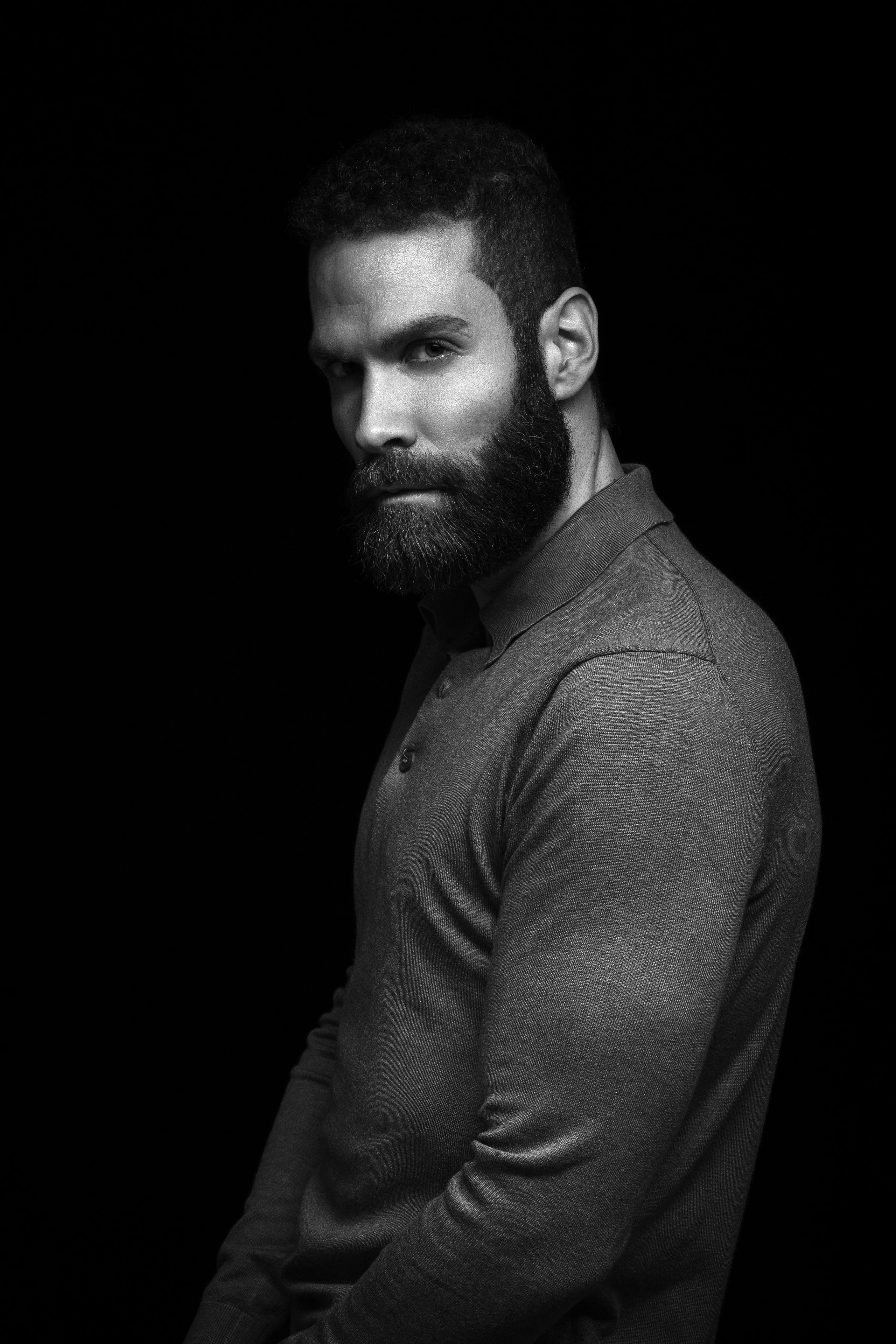 Schwarzweißes maskulines Männerporträt im Low-Key-Stil im Studio