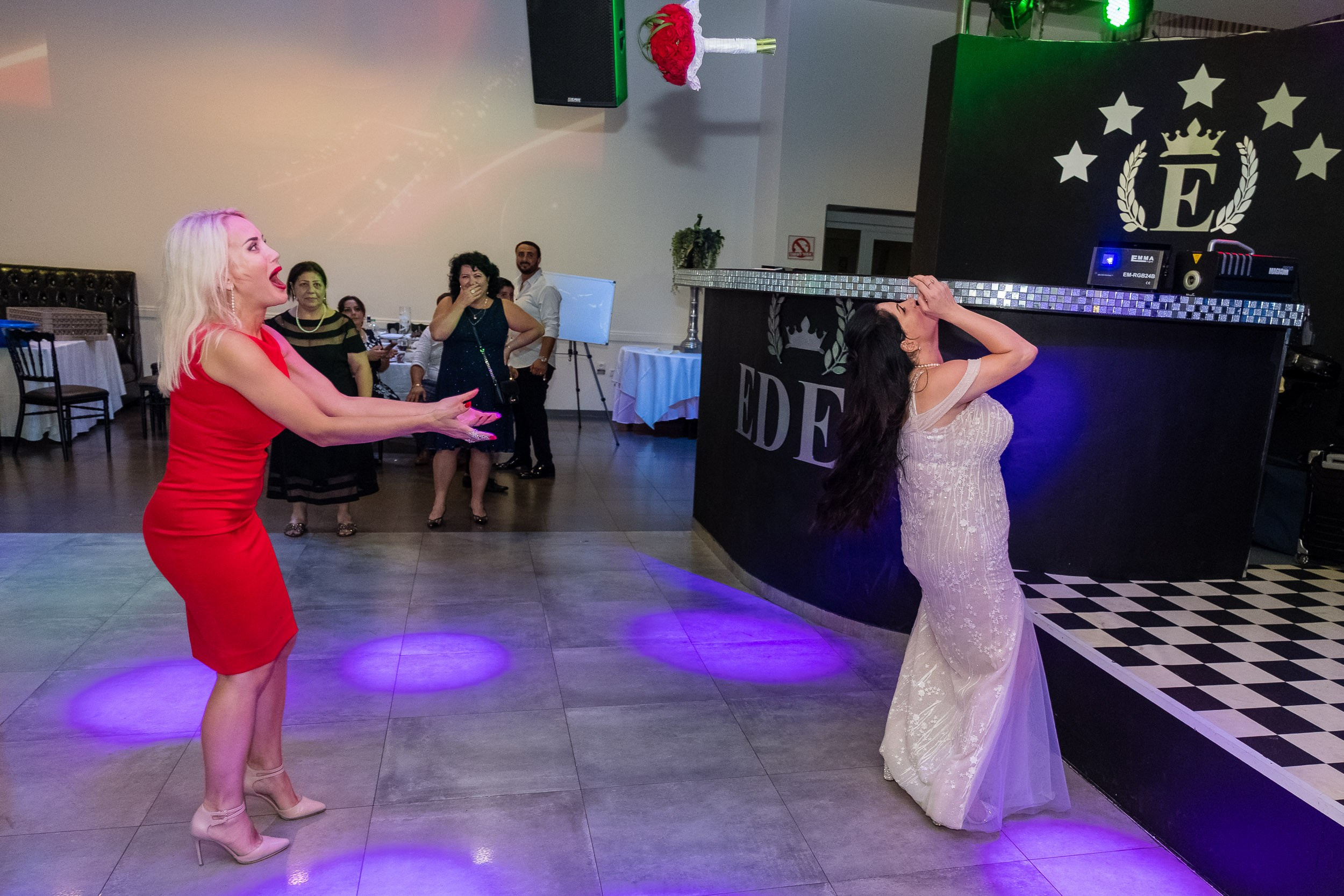 Sara throws her wedding bouquet to friends on the dance floor
