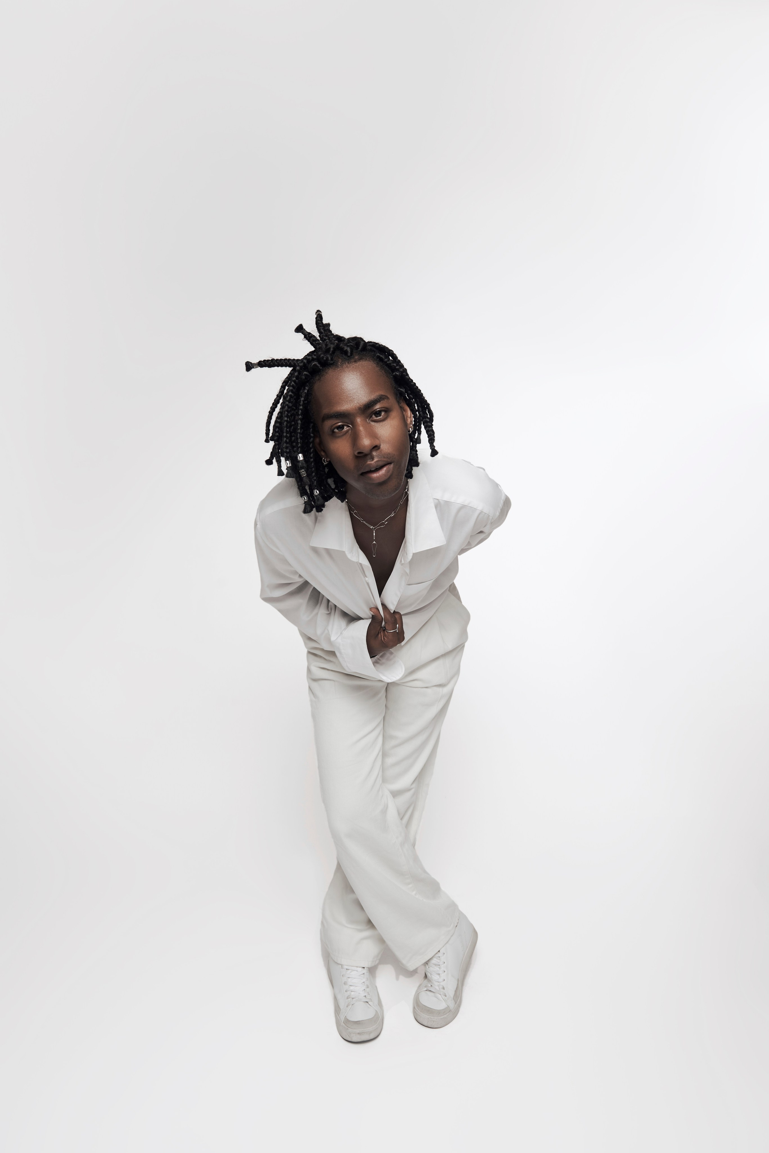 Full-body portrait of a male artist in a clean studio setting