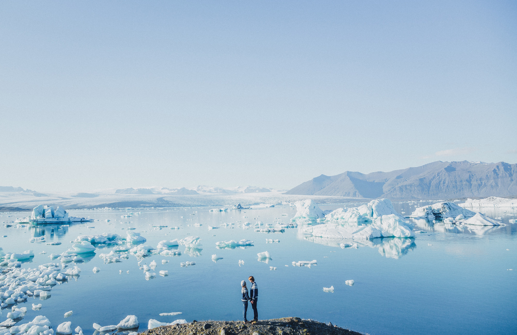 couple stands at a glacier in Iceland
