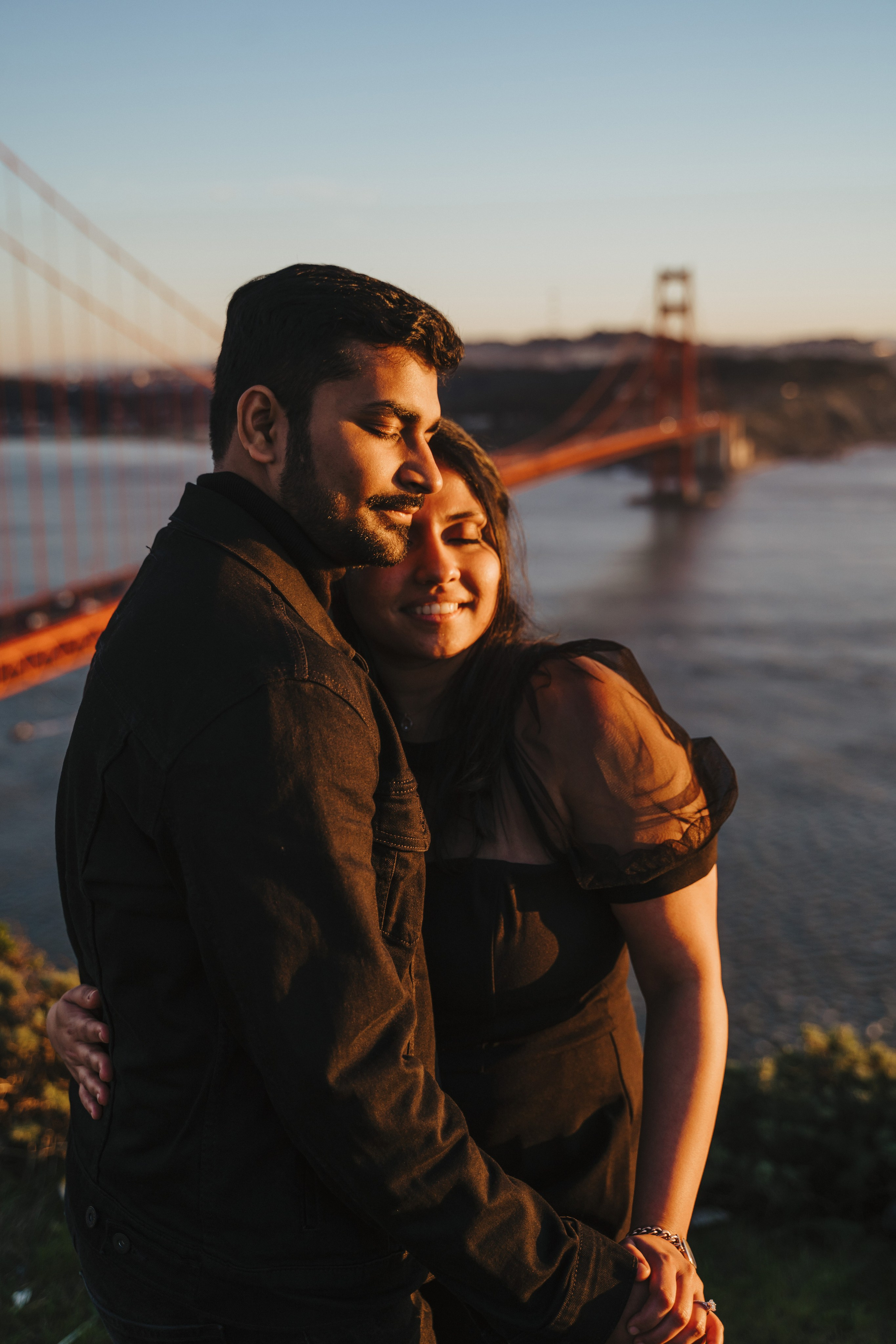 Proposal.  Overlooking the golden San Franisco Bridge sunset with a couple. Photographer Video. 