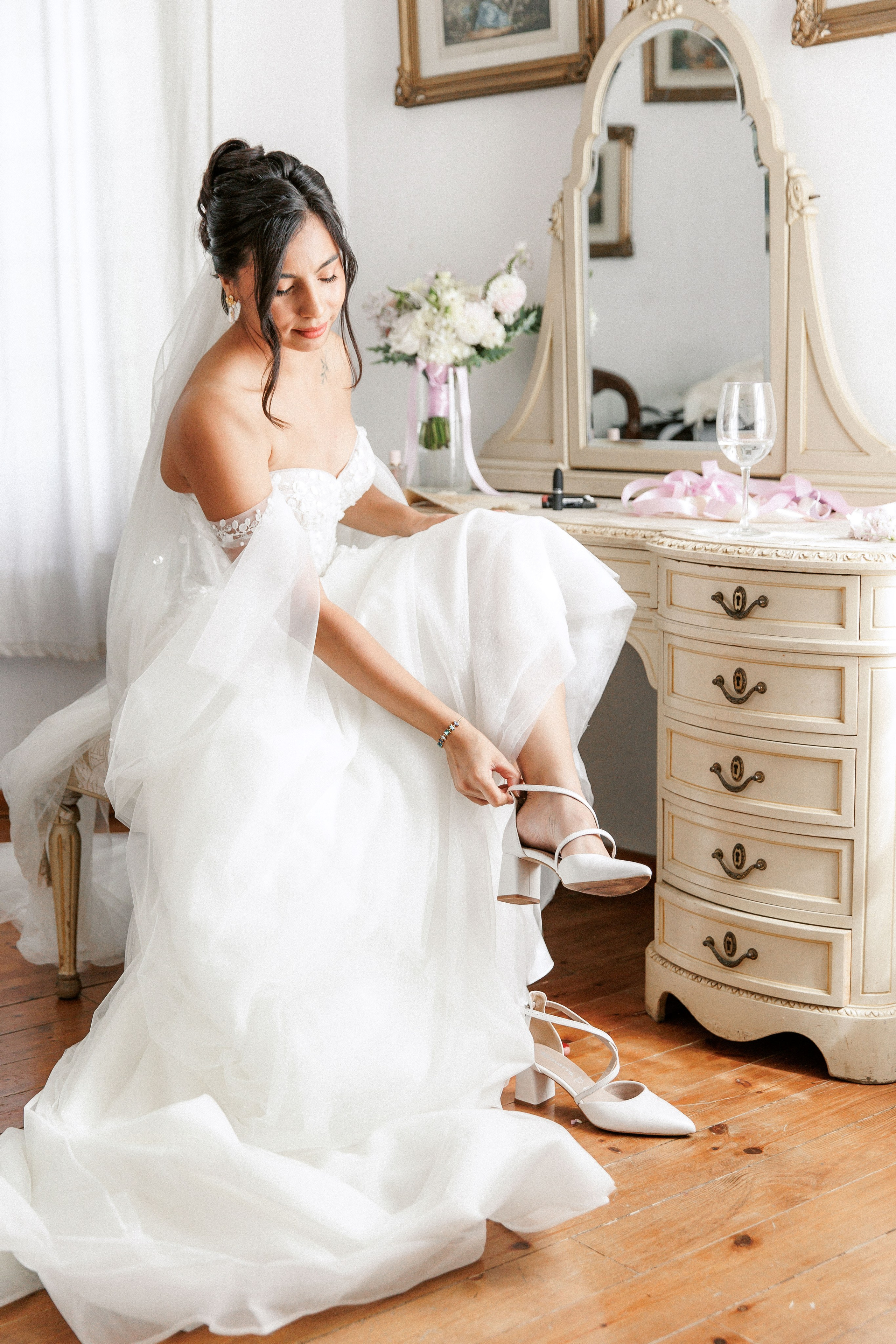 The bride wears stylish wedding shoes and expresses her excitement before the ceremony starts