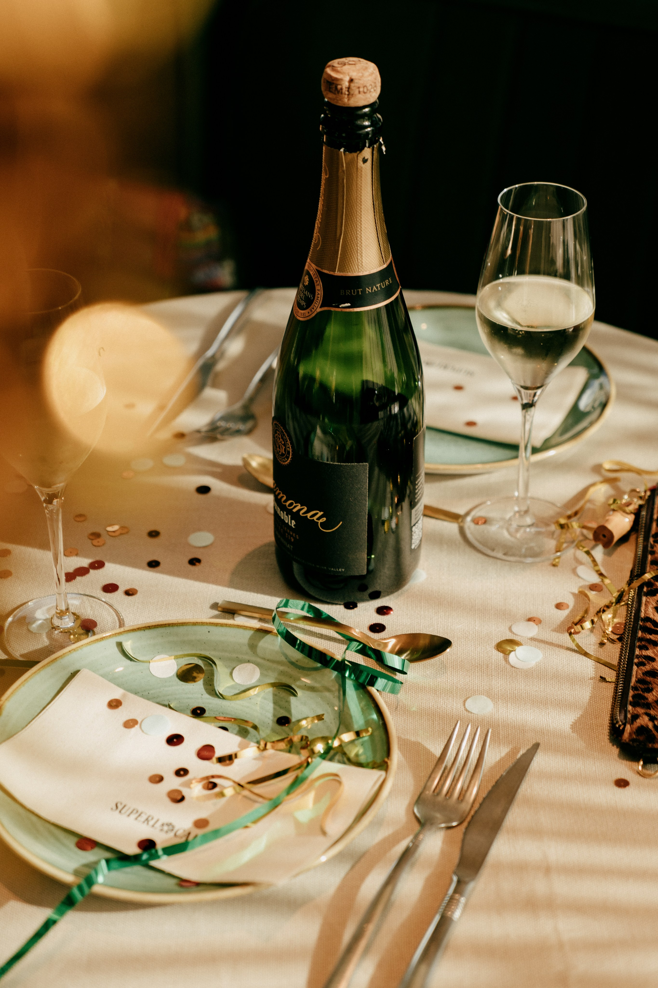 Ambiente cálido en el comedor del restaurante local, con luces navideñas colgantes y clientes brindando.
