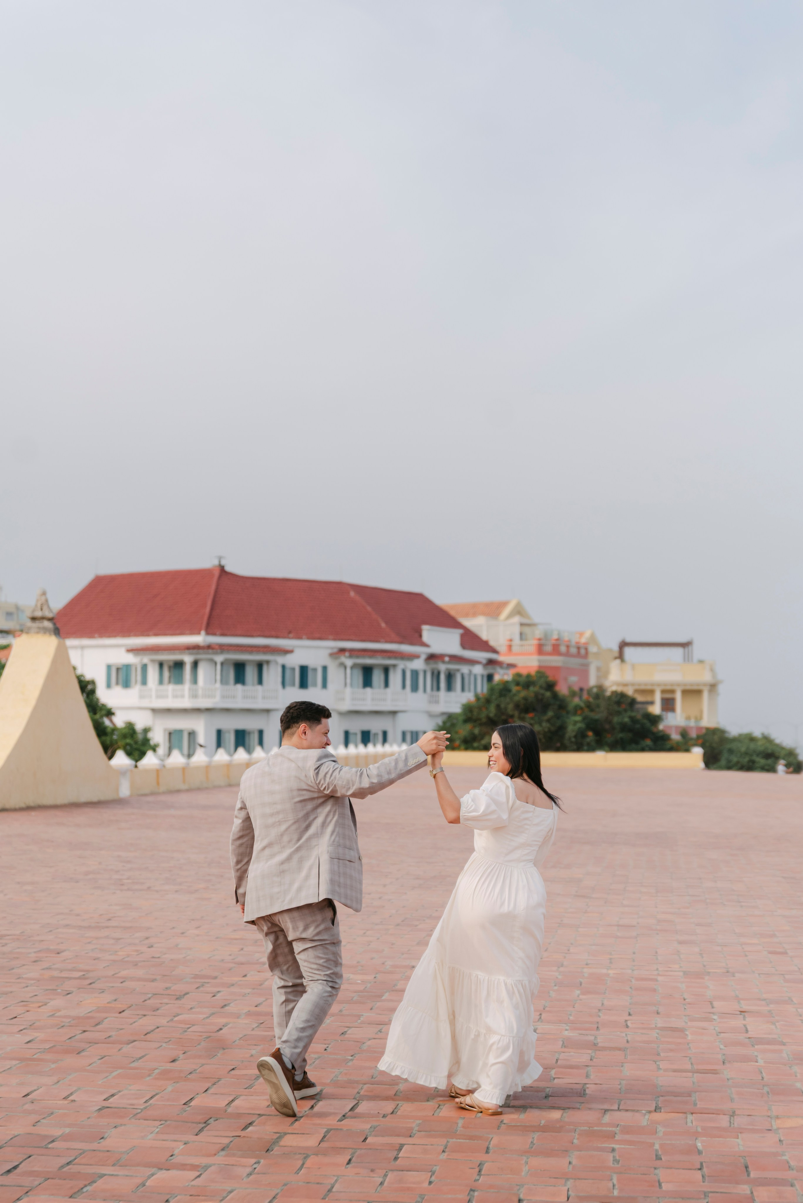 Pareja posando en pared arquitectónica de Cartagena, fotografía cinematográfica artística