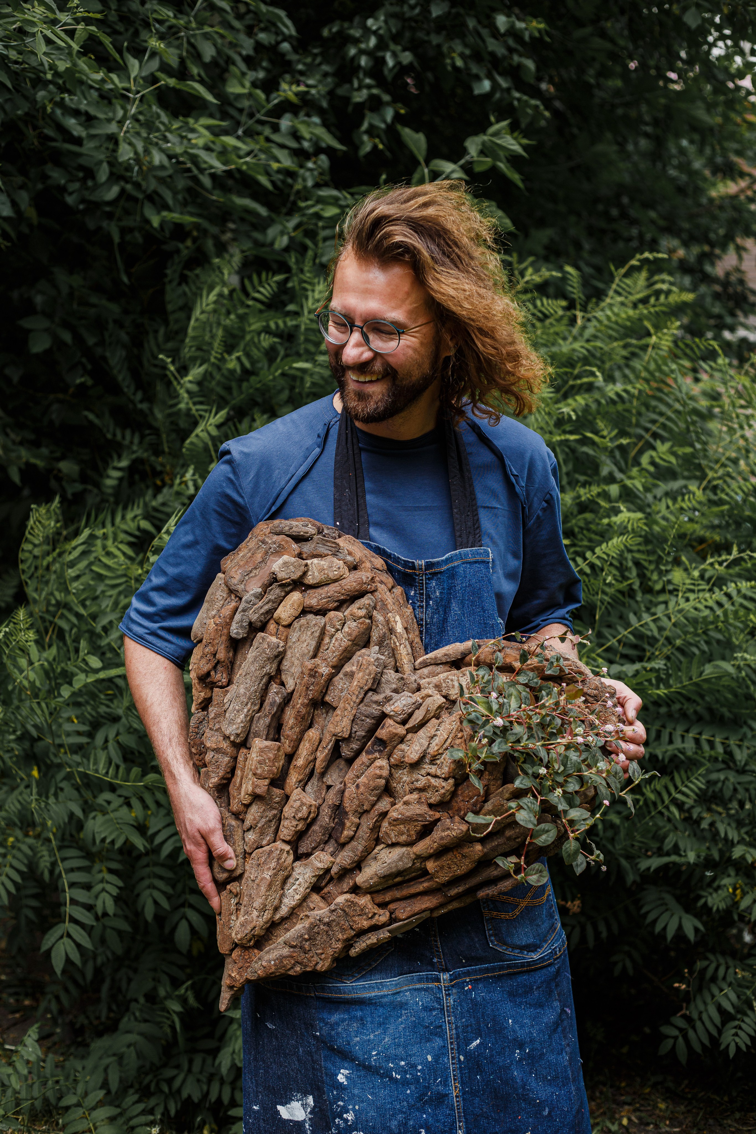 retrato de un florista sobre un fondo de árboles con obra en sus manos