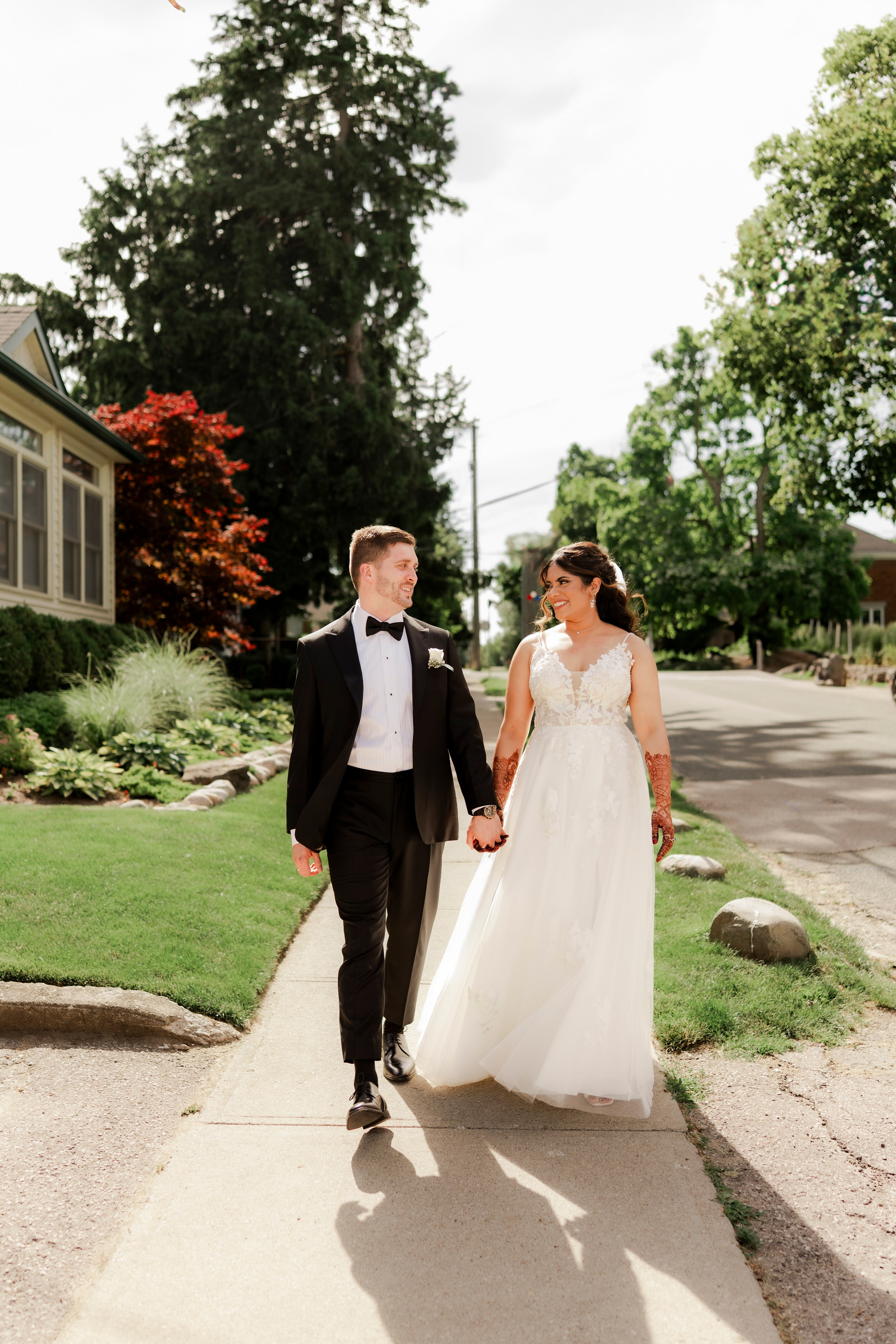 Wedding couple walking on pathway with trees in the background
