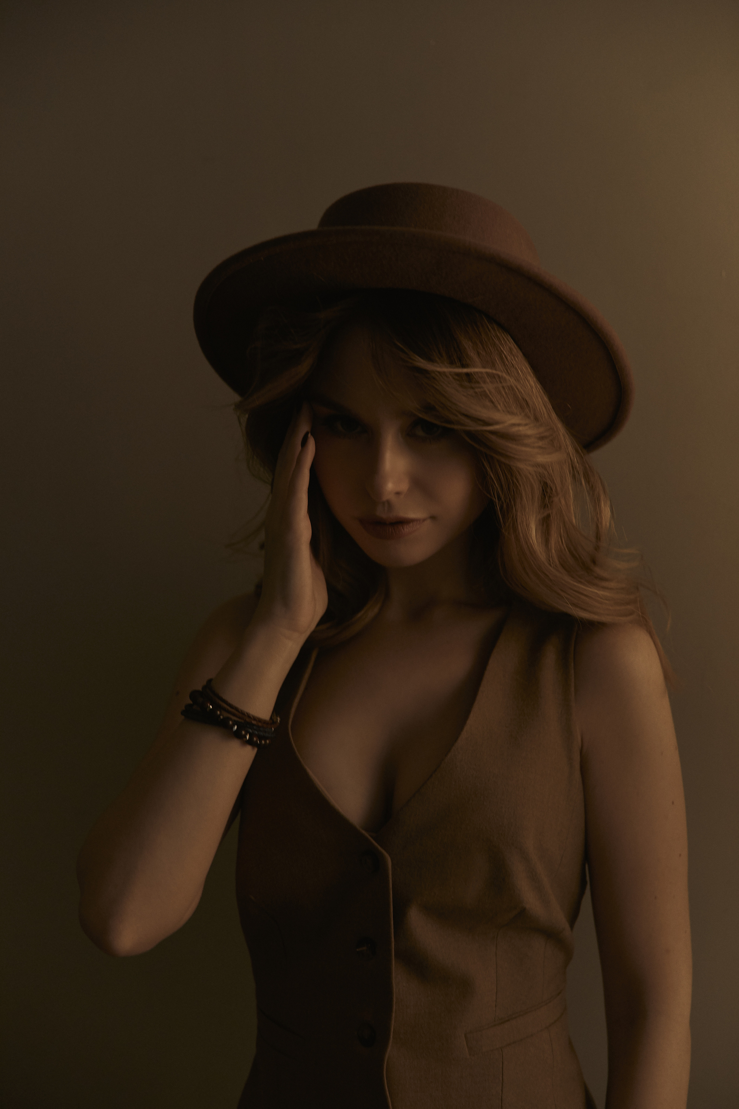 Stylist portrait wearing a hat and west, moody