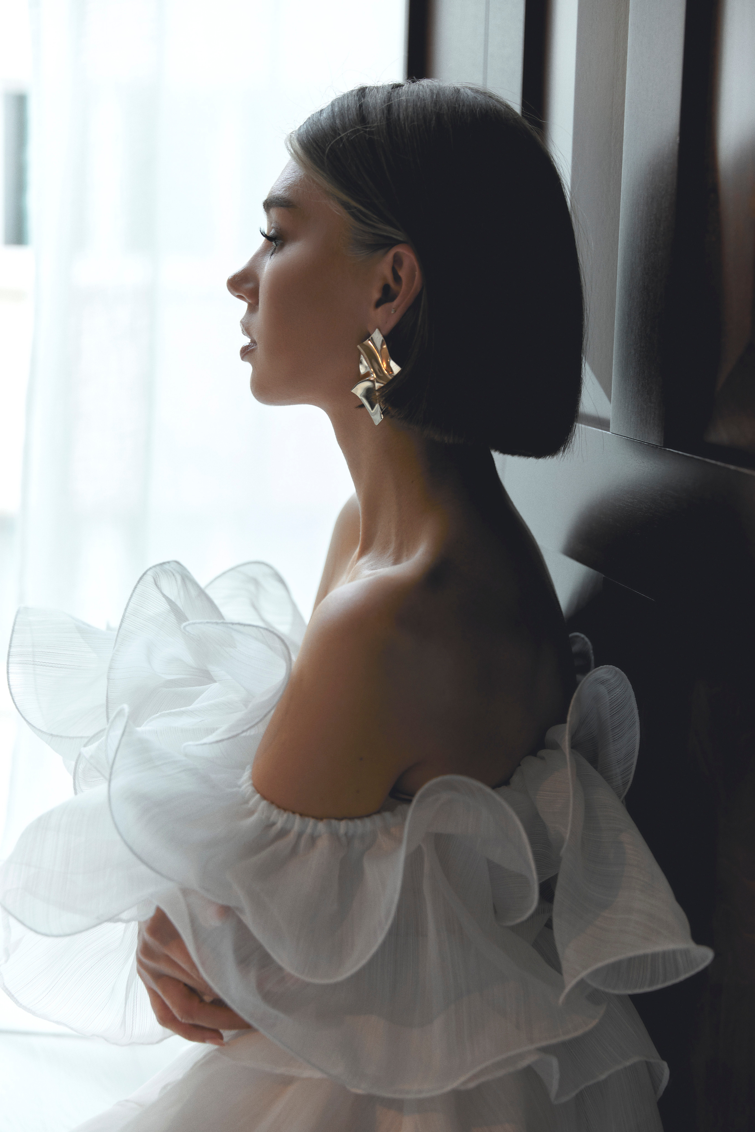 Beautiful giri is sitting next to the window in a wedding dress, Schweinfurt foto, Schweinfurt Fotogeschäft, Schweinfurt fotoshooting, Schweinfurt Hochzeit , Frankfurt fotograf