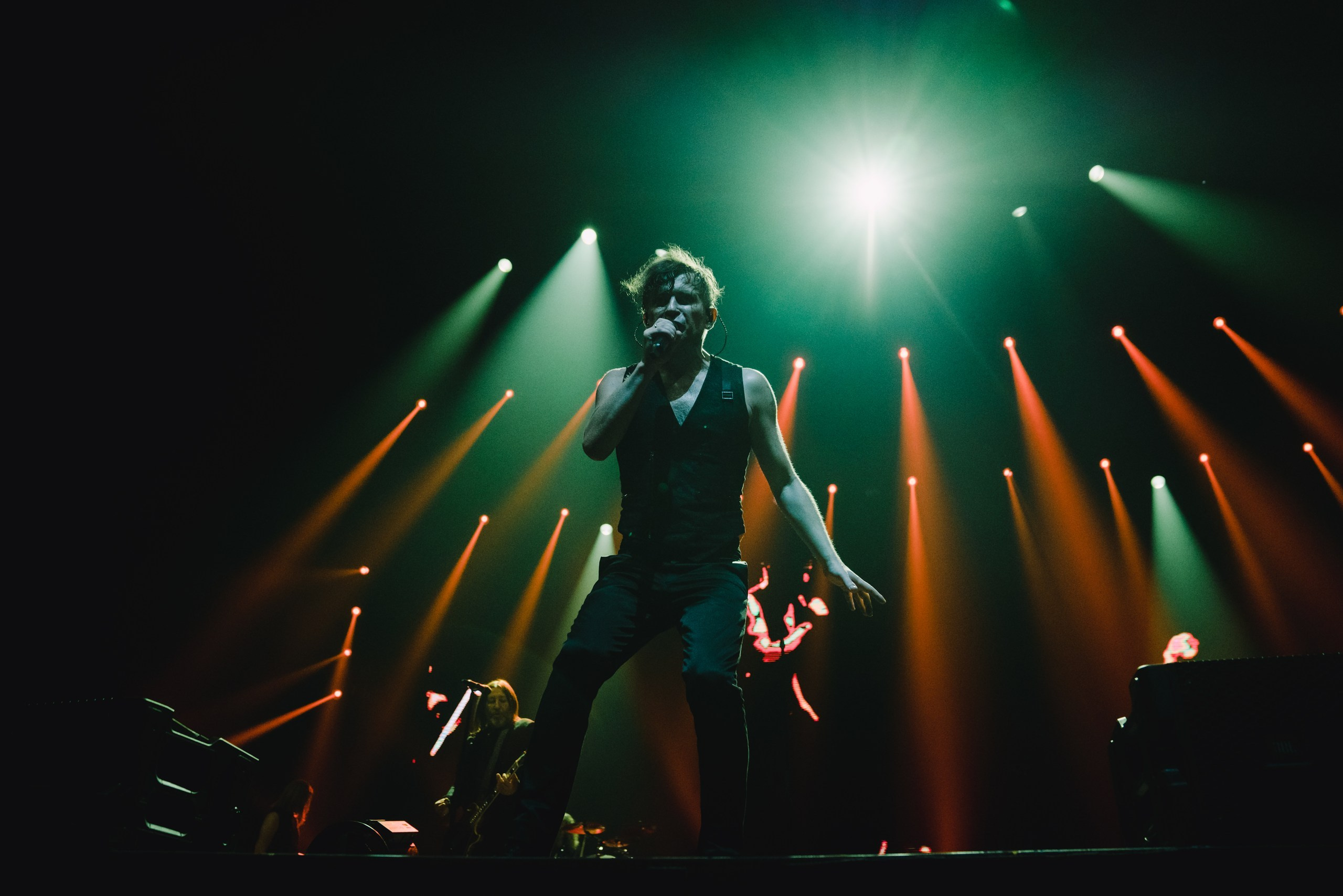 A celebrity DJ interacting with fans from the stage at a luxury pool party.