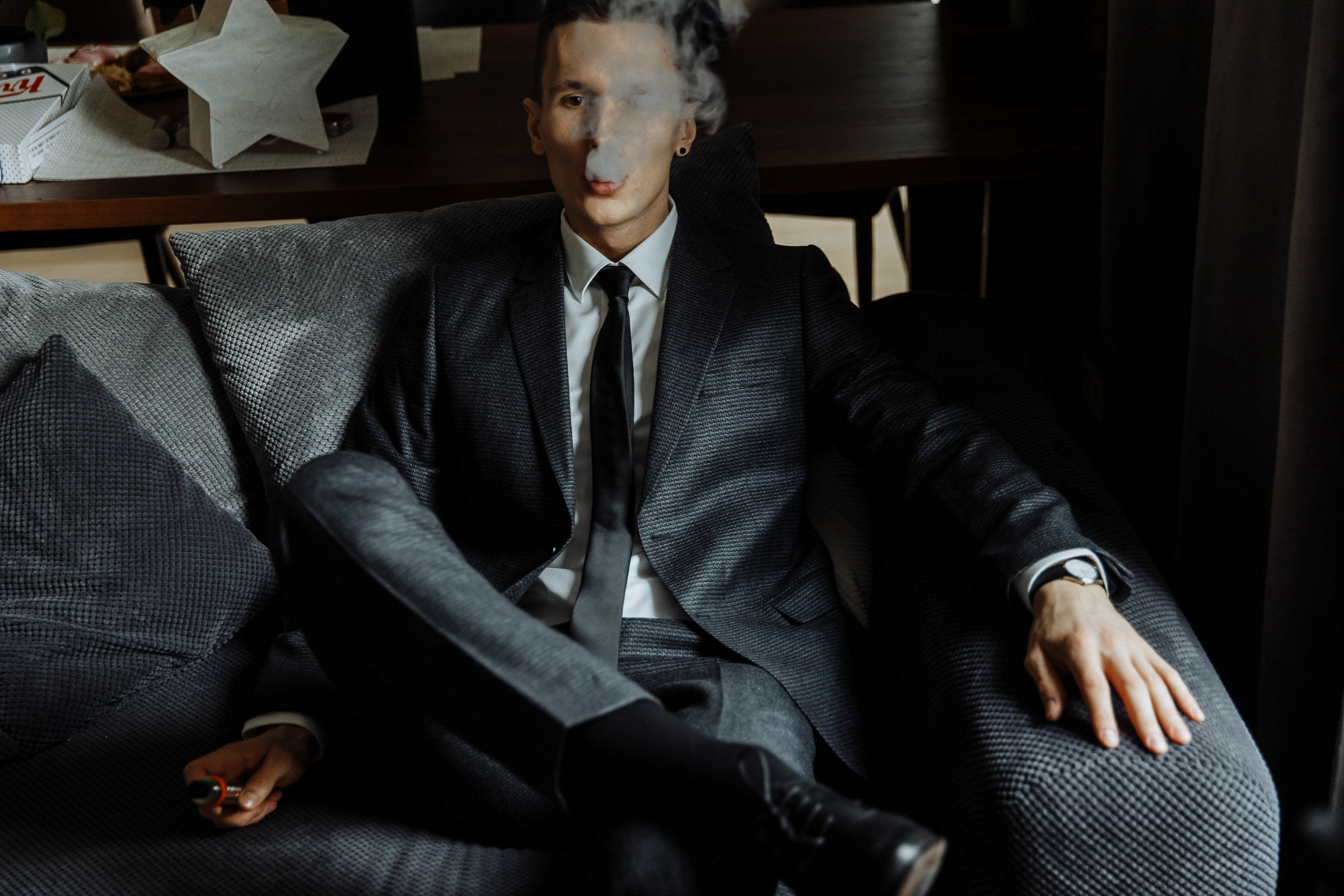 Groom sitting with smoke, by Tanya Bogdan, Bude editorial and reportage wedding photography.  