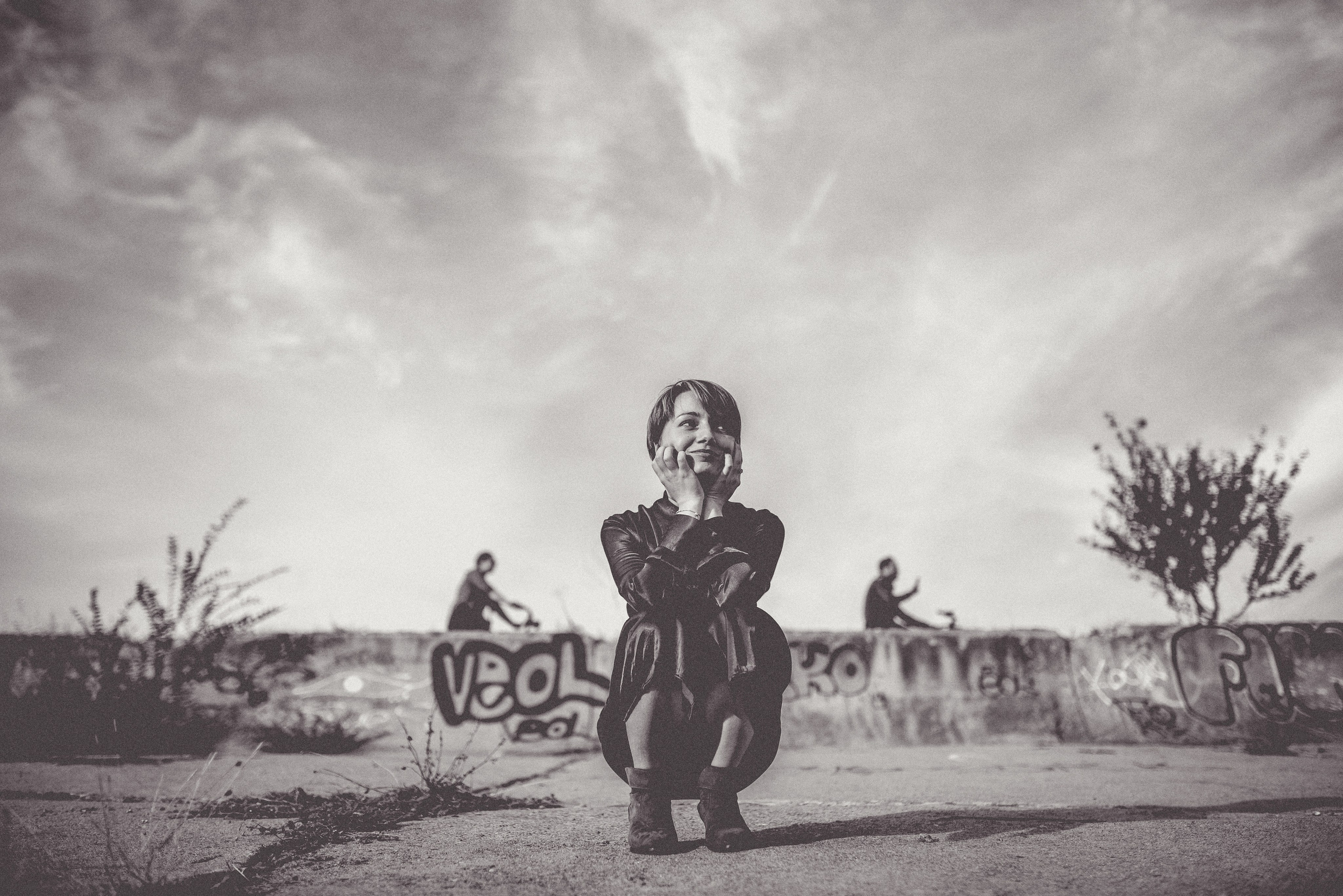 Portret alb-negru Raluca ghemuită pe beton cu graffiti în Parcul Văcărești, Photosinteza