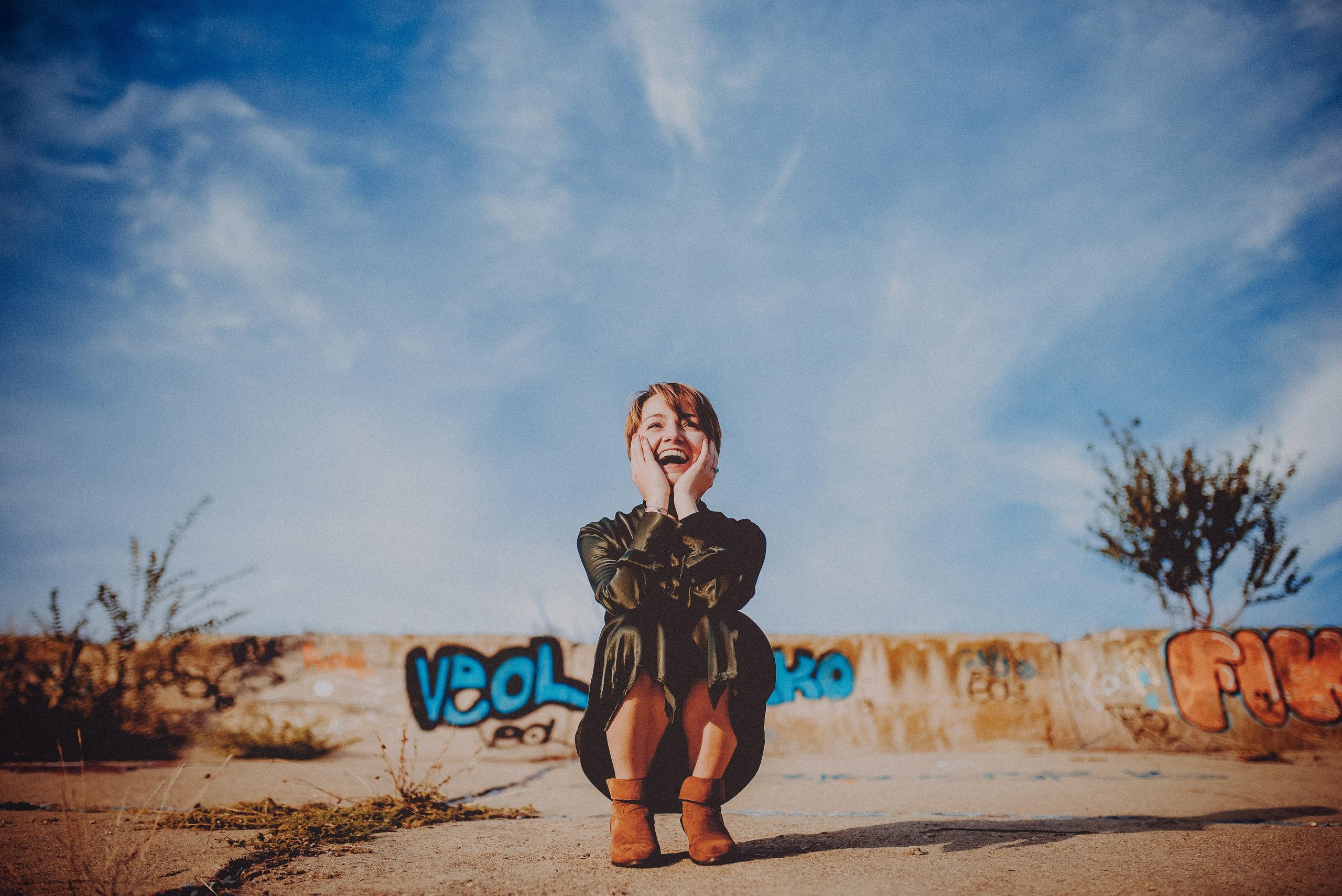 Portret expresiv cu Raluca ghemuită și zâmbind în Parcul Natural Văcărești, foto Photosinteza