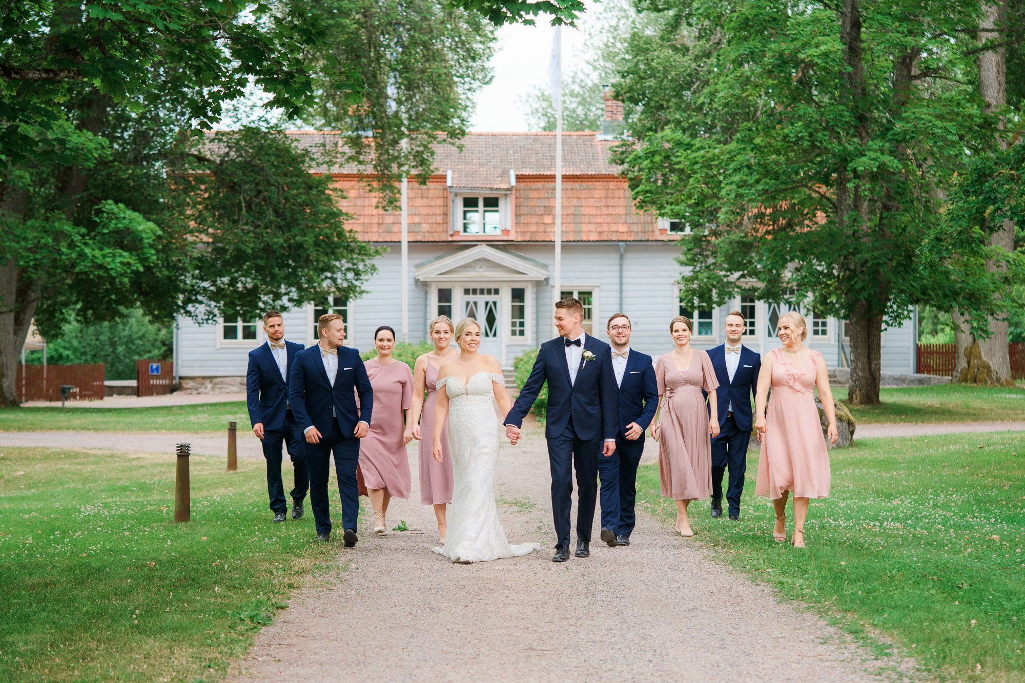 Morsian, kaasot, sulhanen ja bestmanit kävelevät kameraa kohti