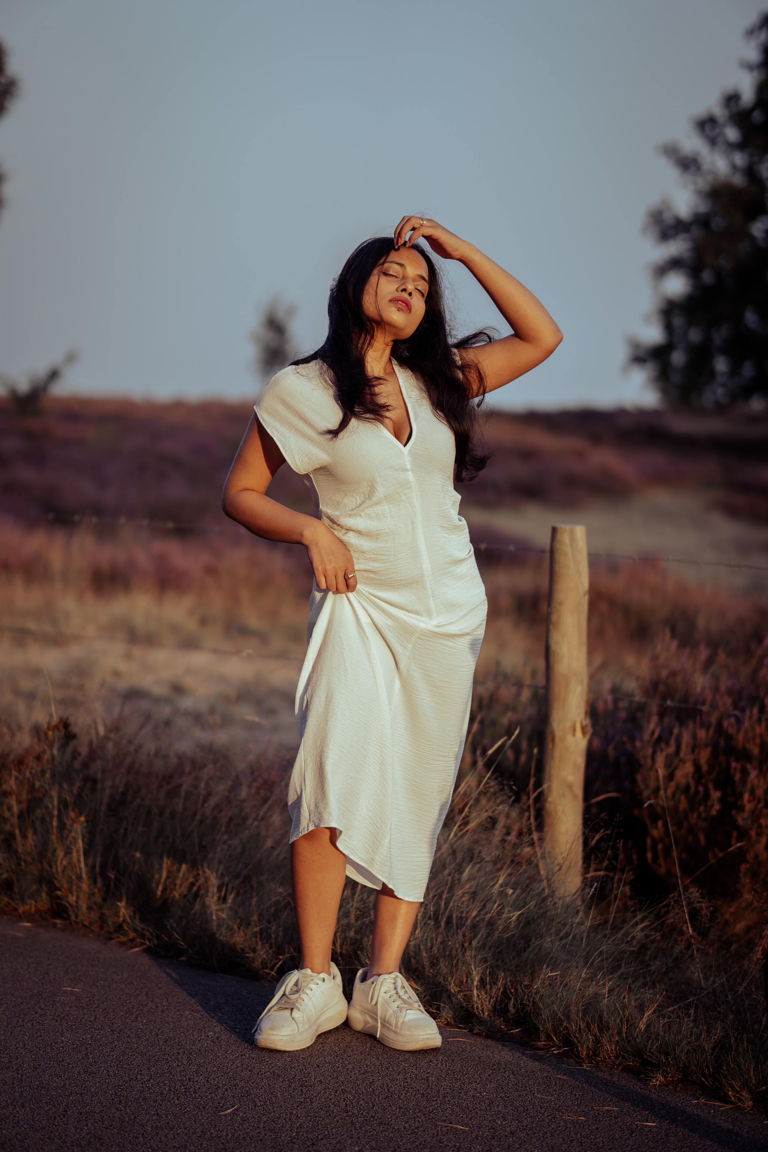 woman standing near veluwe heather fields at golden hour