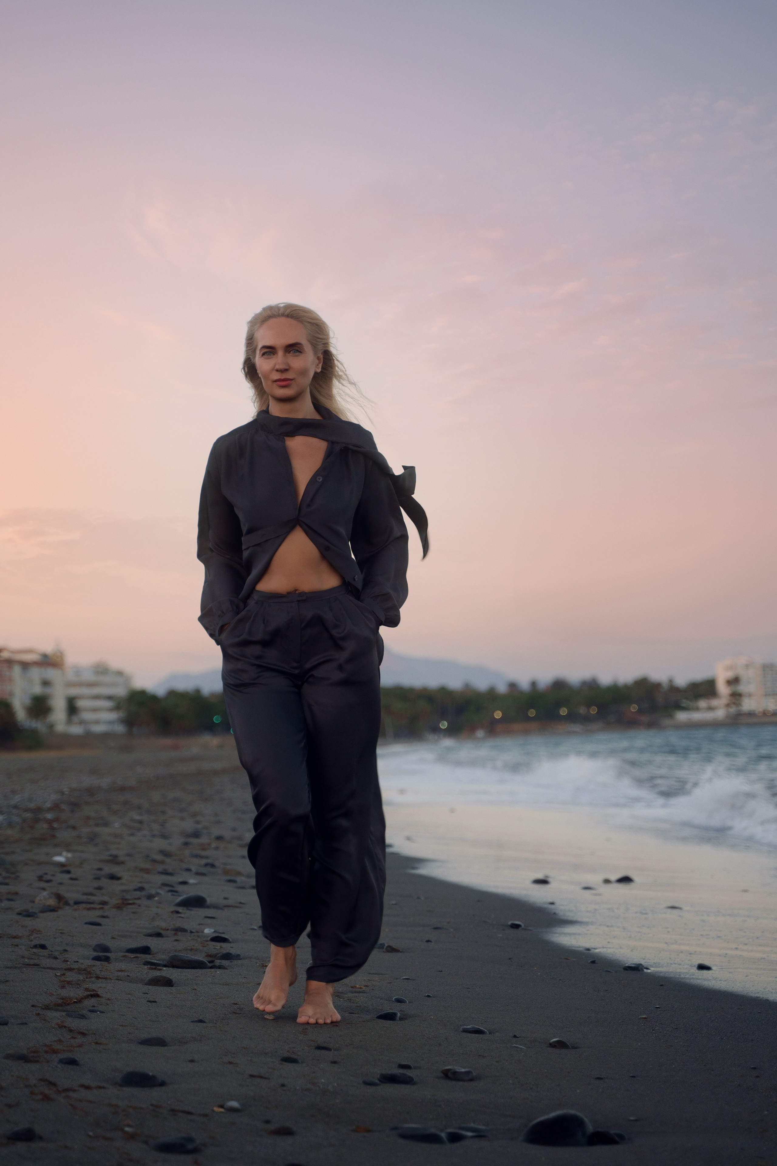 Blonde model posing on the sandy shores of Estepona beach, photographed by a Marbella-based portrait photographer