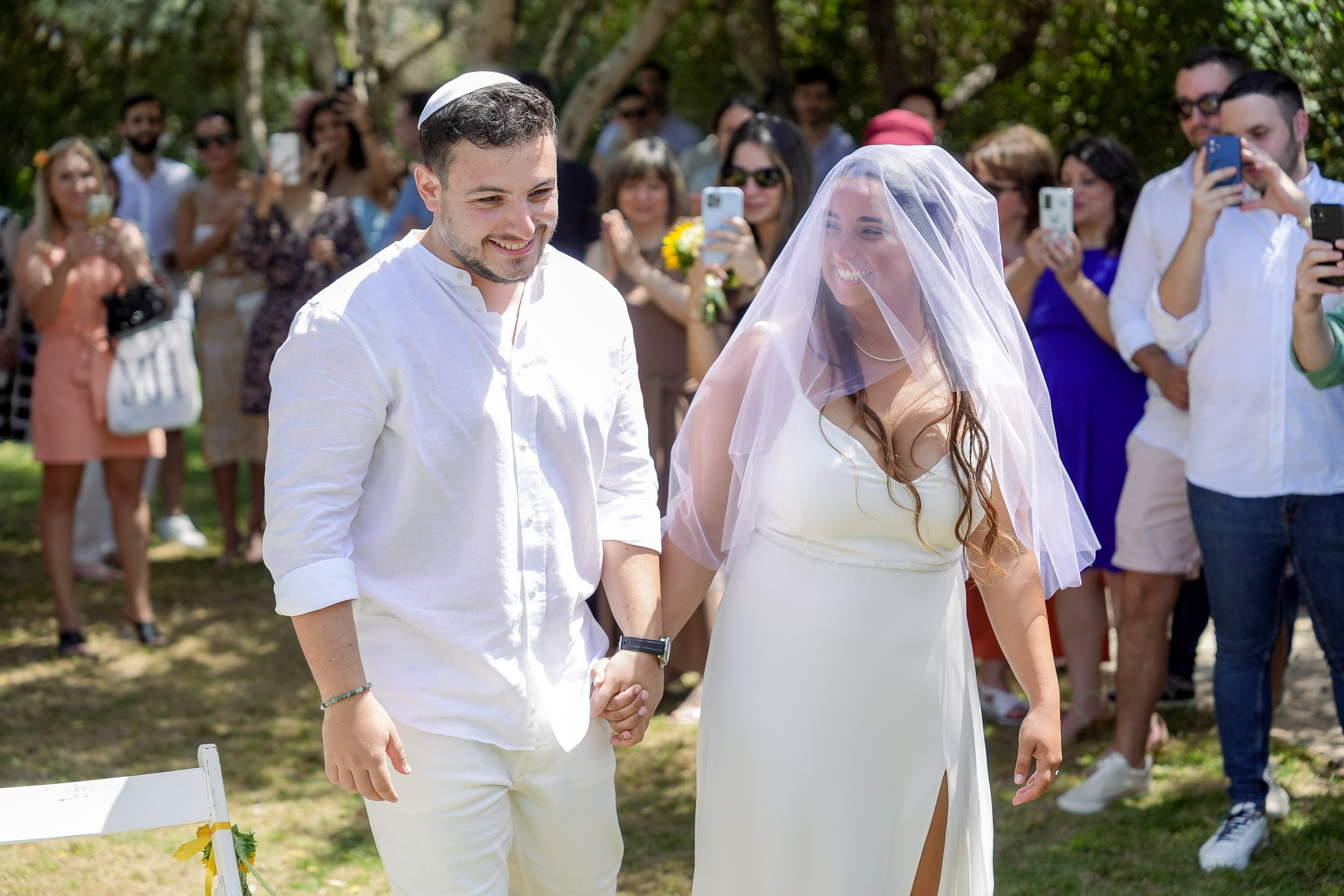Talia and Ronen walk hand in hand towards the chuppah
