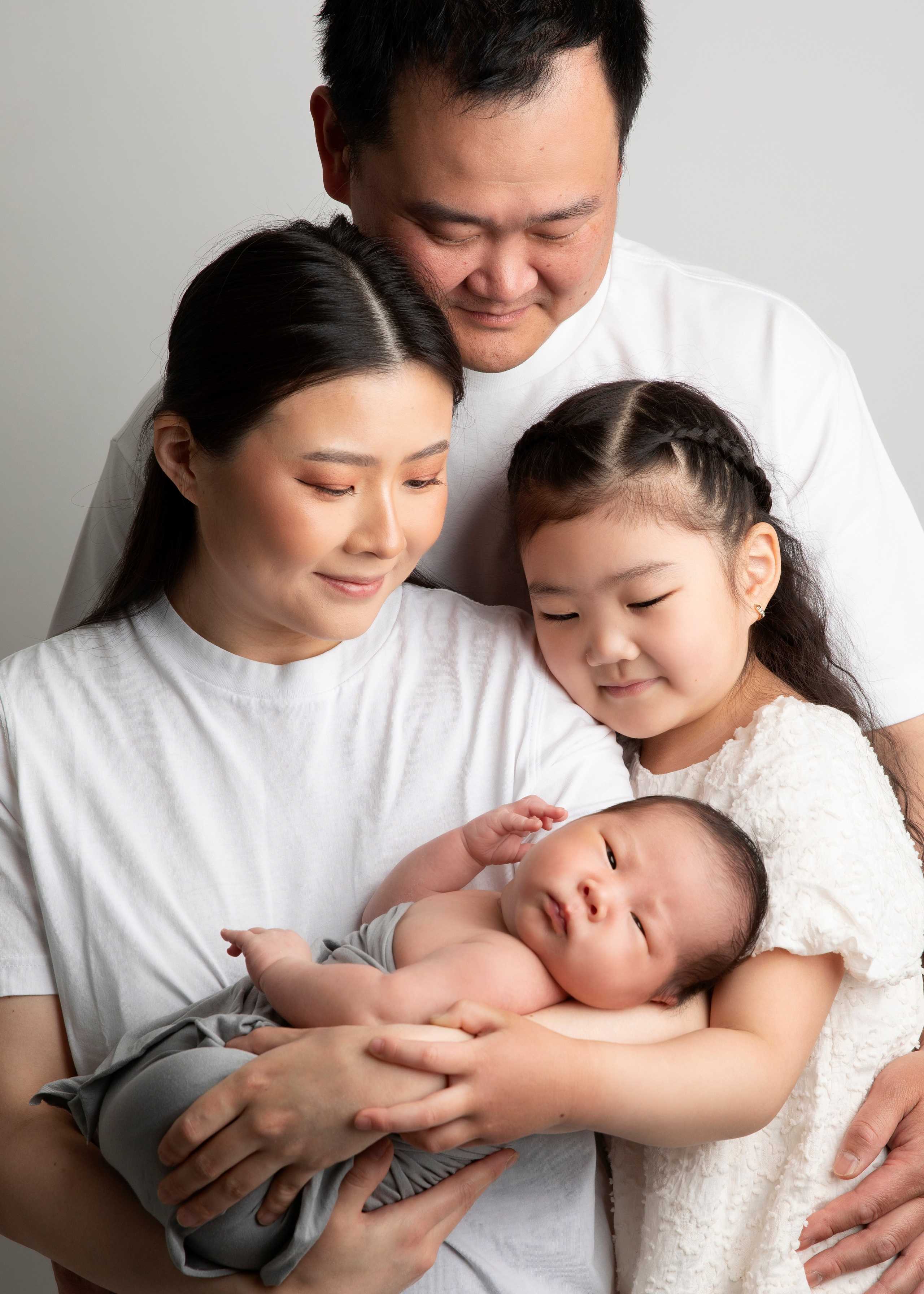 Familjen samlad med sitt nyfödda barn, ett fotografi från fotosessionen som för alltid bevarar kärleken