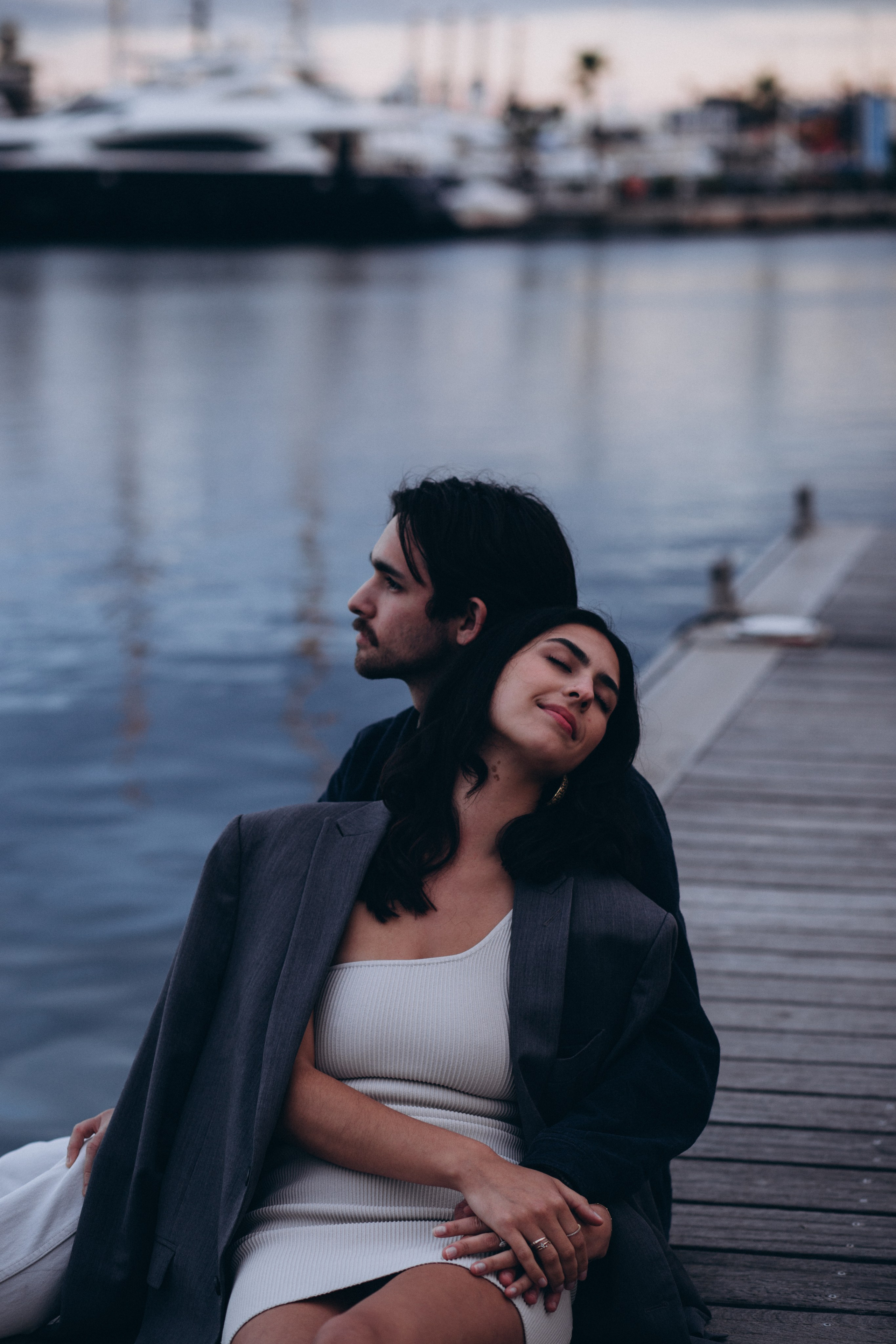 Romantic couple photoshoot in Malaga, Spain — a serene moment of love as the couple relaxes by the harbor, perfect for those searching for intimate and emotional love story photography sessions in Malaga and coastal Spain.