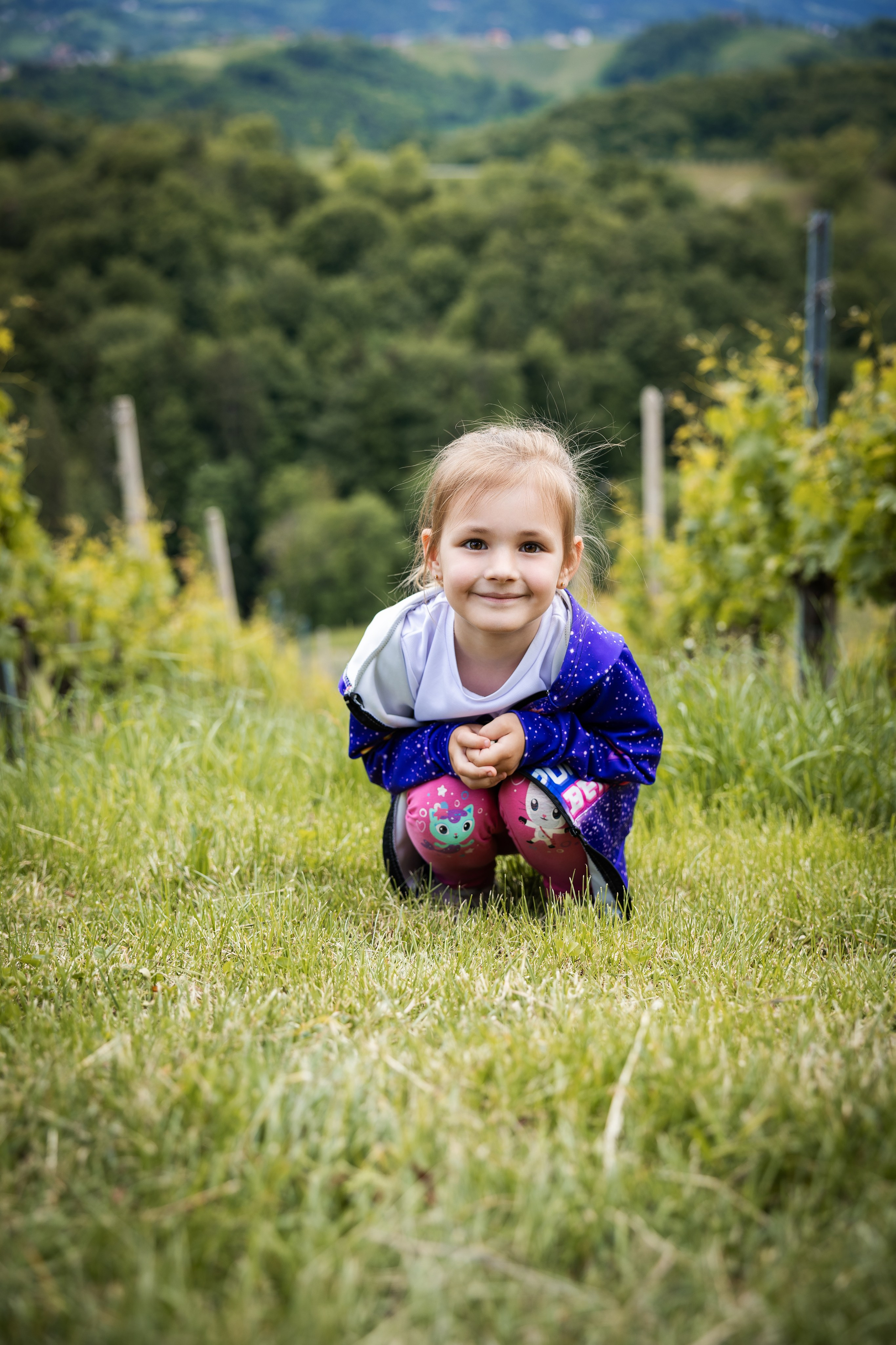 Mala raziskovalka med vinogradi. Fotograf Zoja | Fotografiranje krsta, poroke in družine v Sloveniji