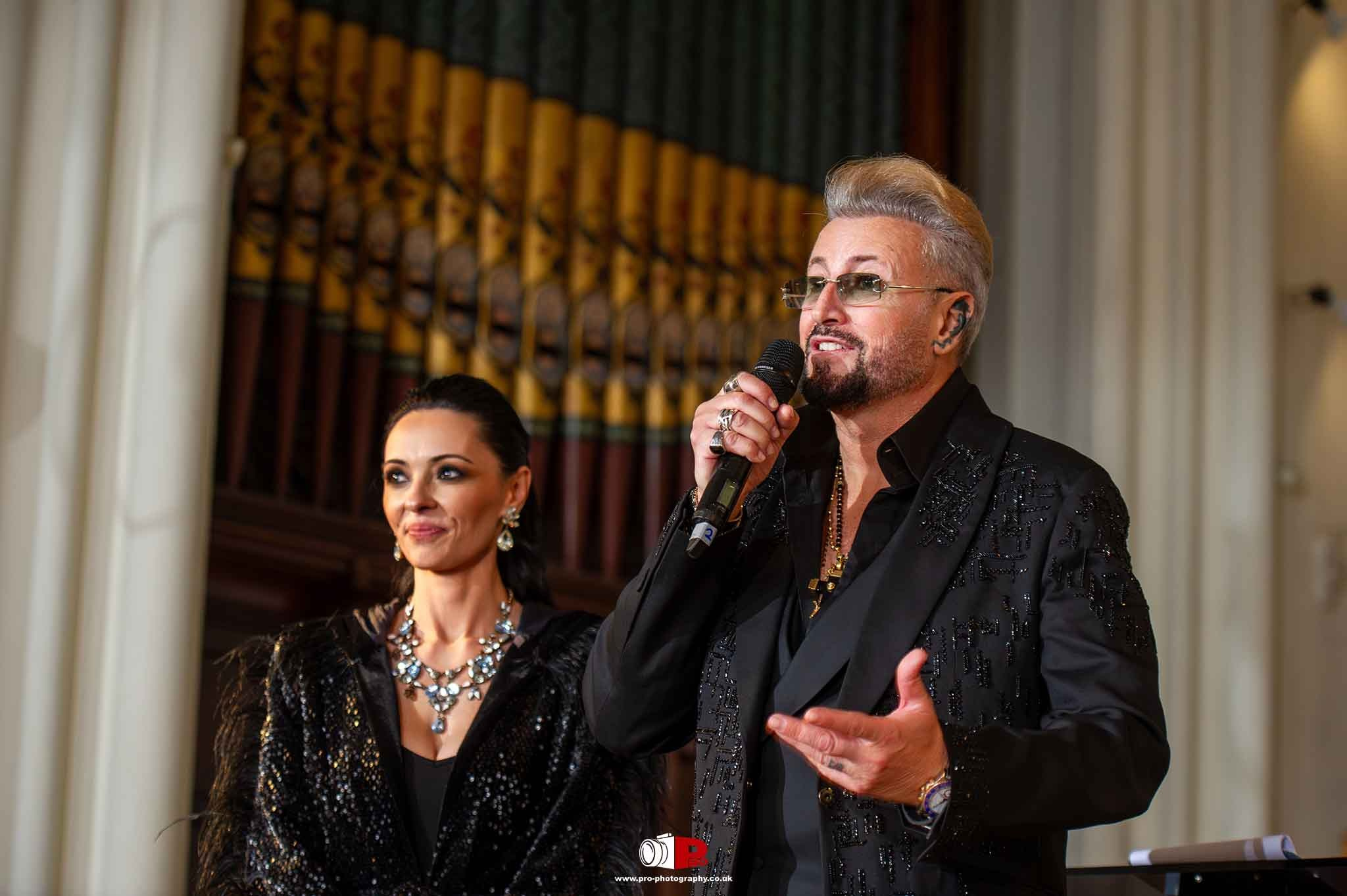 Famous designer Catalin Botezatu gave a heartfelt speech on stage, flanked by a stylishly dressed woman, Cosmina Pasarin.