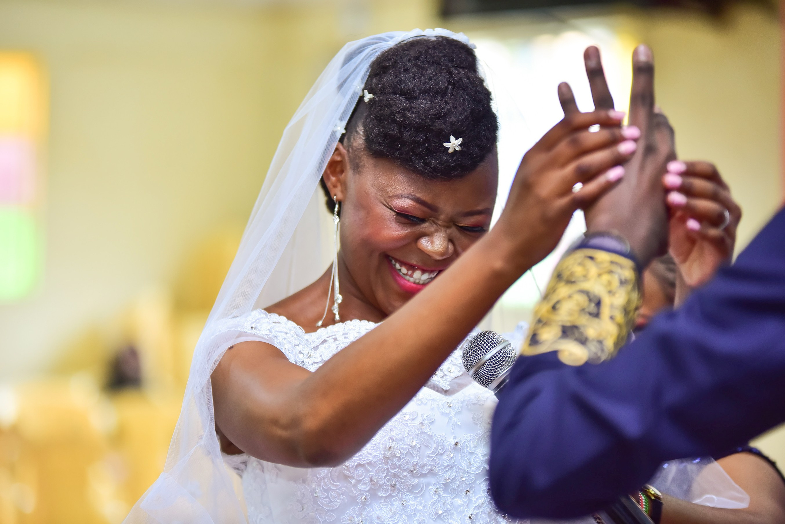 A bride blushing as she puts the ring on her husband- Nairobi wedding photographer