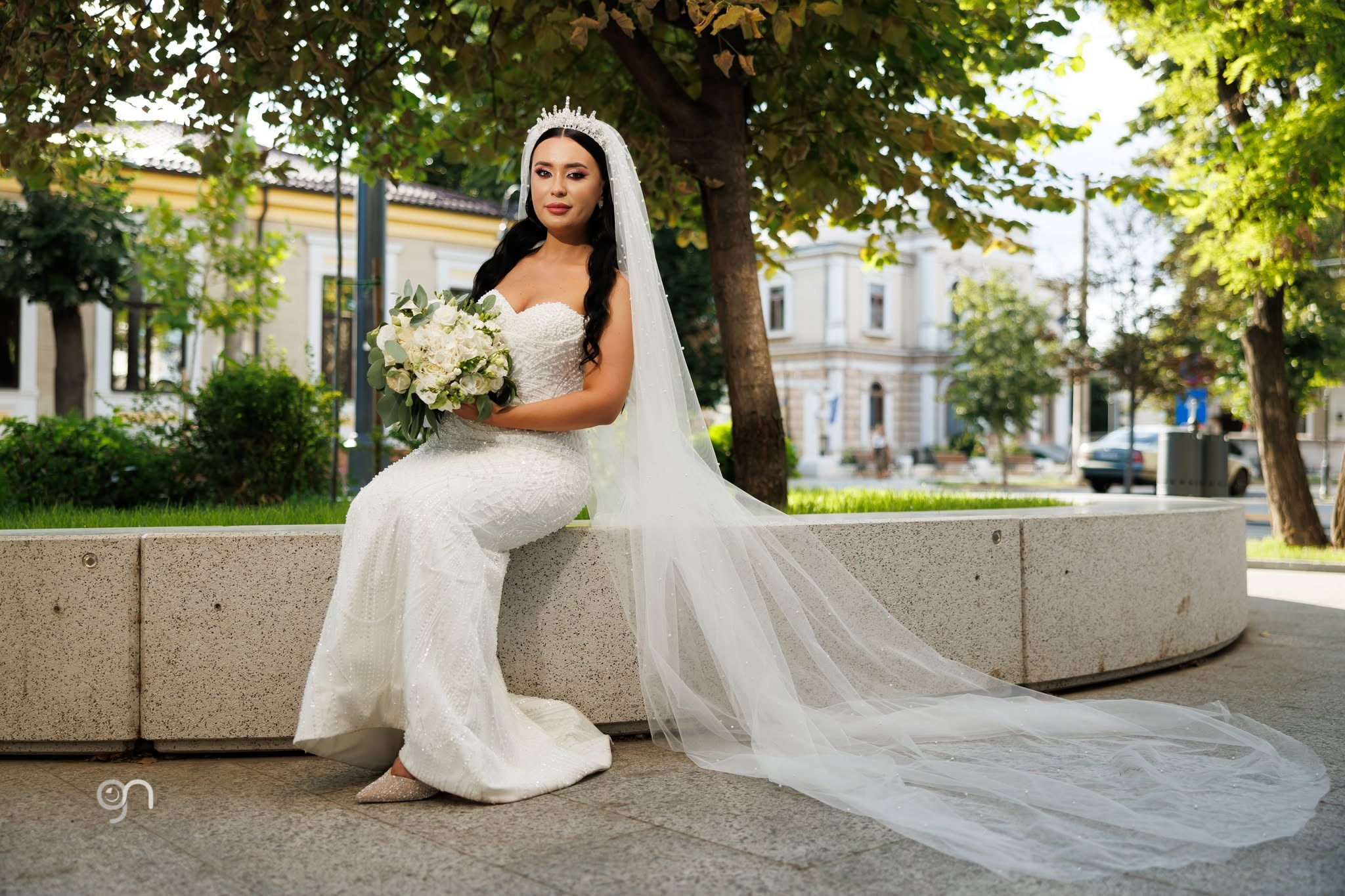 Mireasa admirându-și buchetul într-un portret elegant de nuntă.