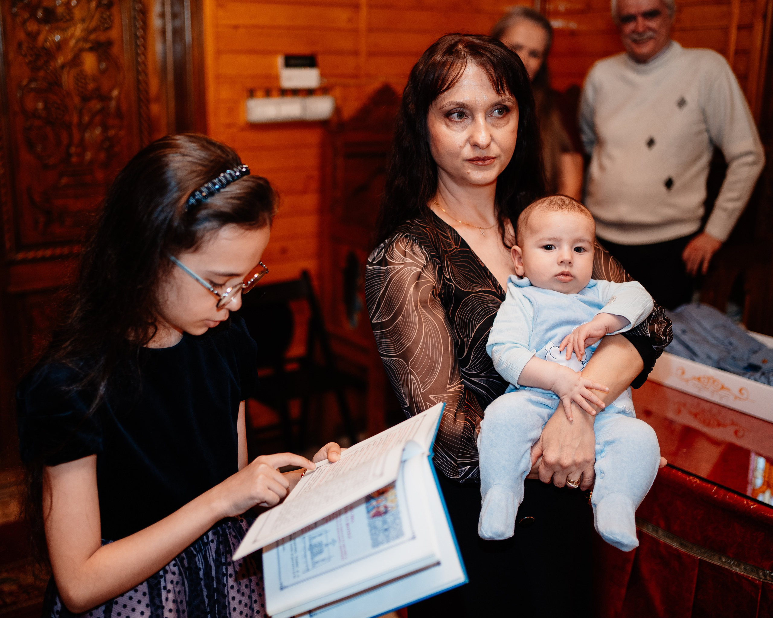Instantaneu plin de tandrețe dintre părinți și bebeluș în ziua botezului, realizat în Bucuresti. Fotografie profesională de botez, capturând emoțiile autentice ale familiei într-un decor luminos și cald