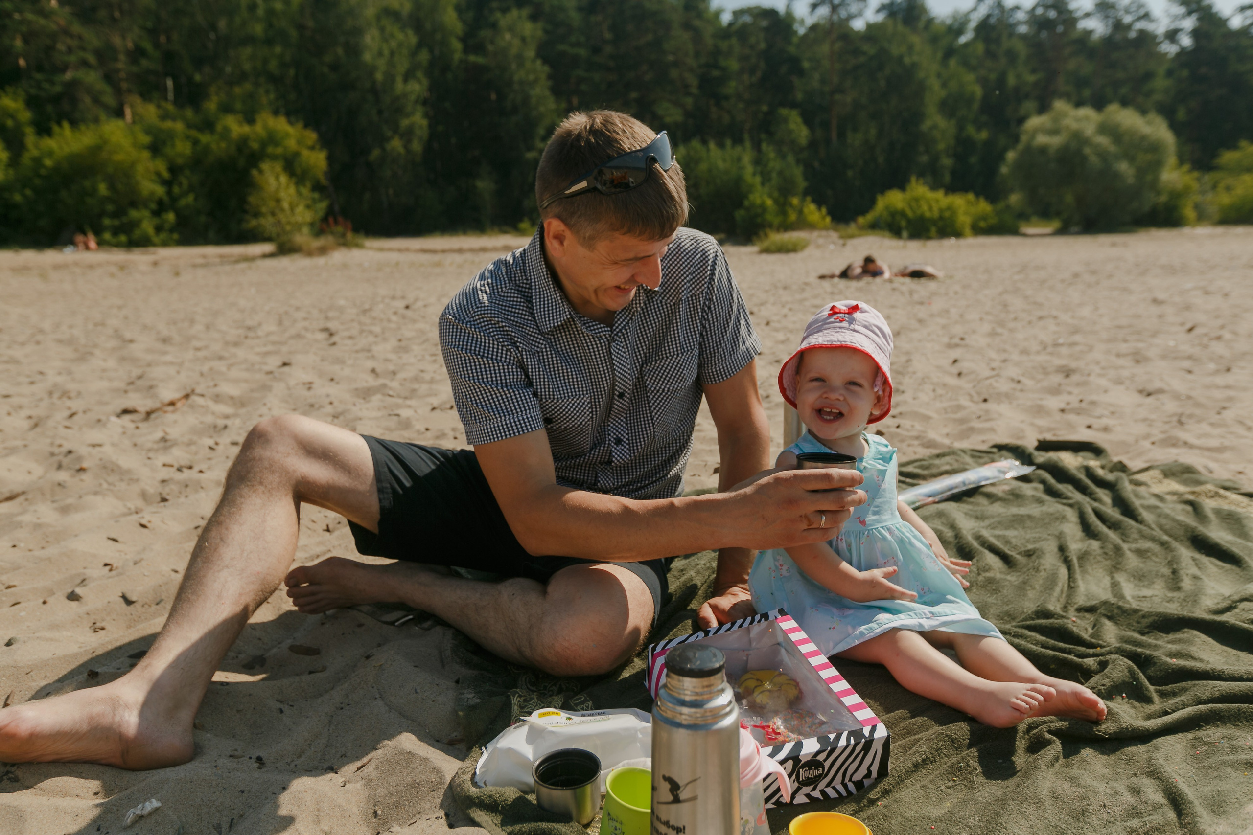 Familia volando una cometa en el lago y comiendo donas. Fotógrafo de retrato, familia y reportajes en Valencia | España | Europa Vitalii Lumier
