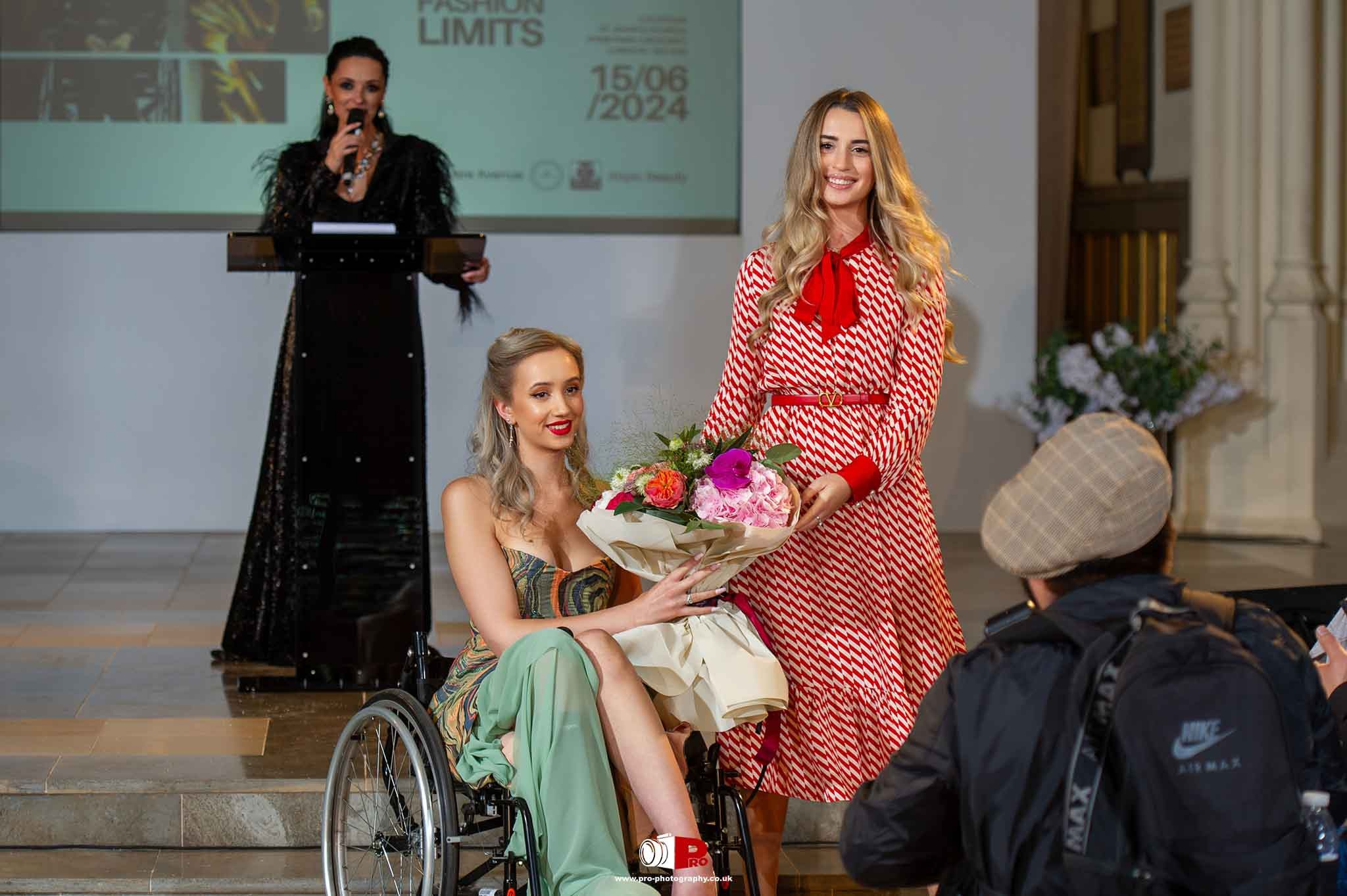 A woman in a wheelchair receiving flowers during an inspiring award ceremony event.