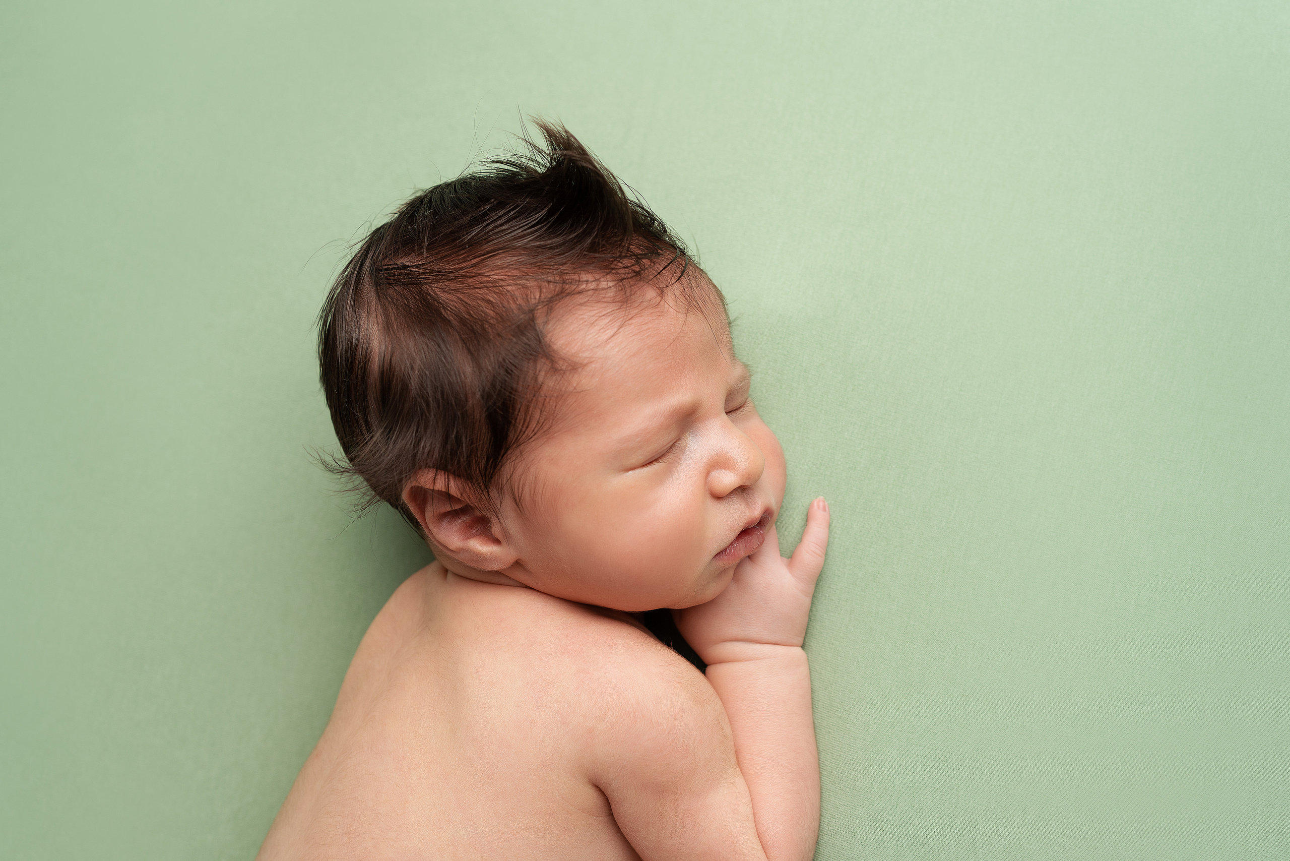 Kleine Wunder in Grüntönen: Neugeborene in bezaubernden Schlafhaltungen
