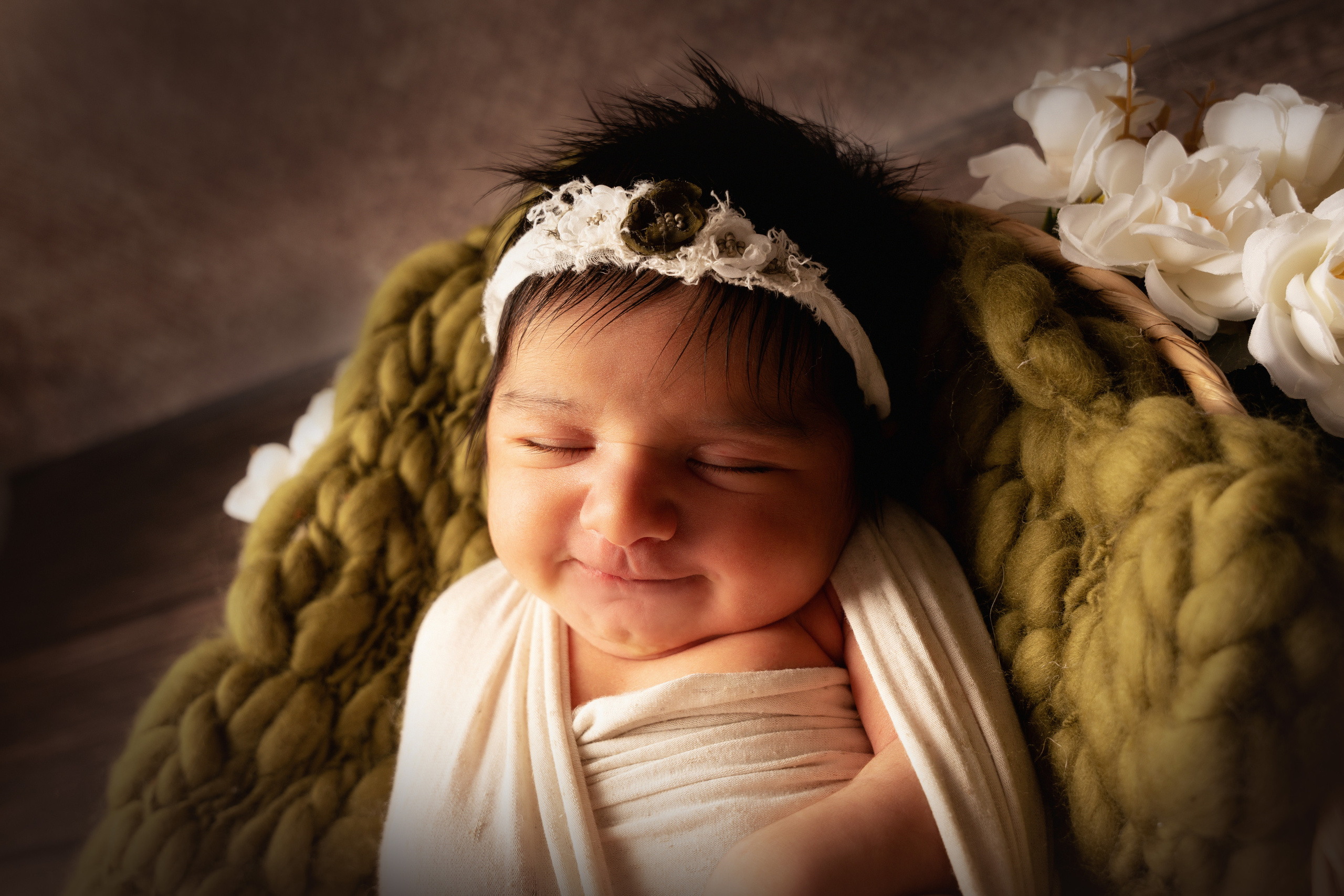 lächelndes Baby in dunkelgrüner Deko