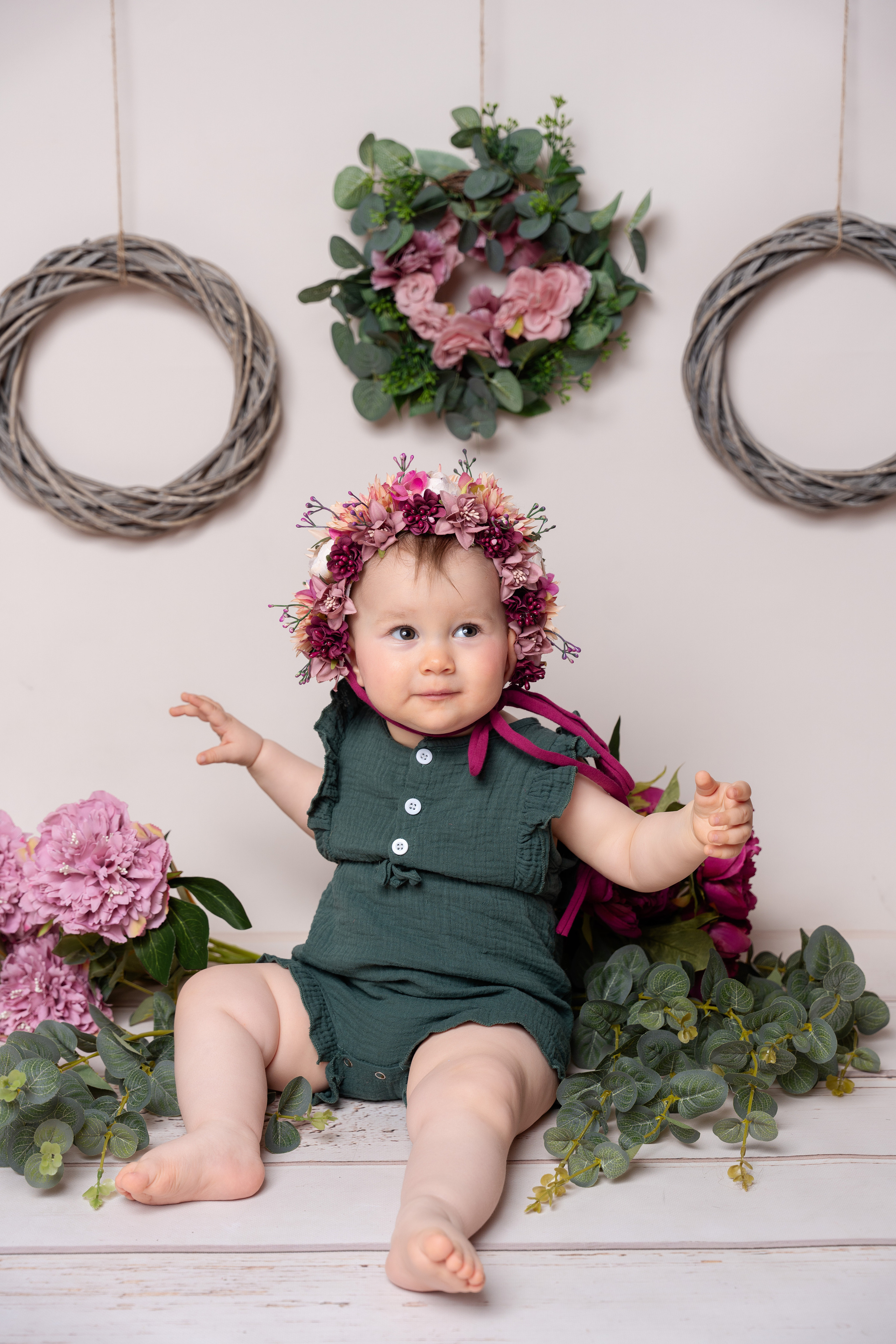 Pfingstrosen kombiniert mit einem Blumenkranz auf dem Kopf eines einjährigen Mädchens